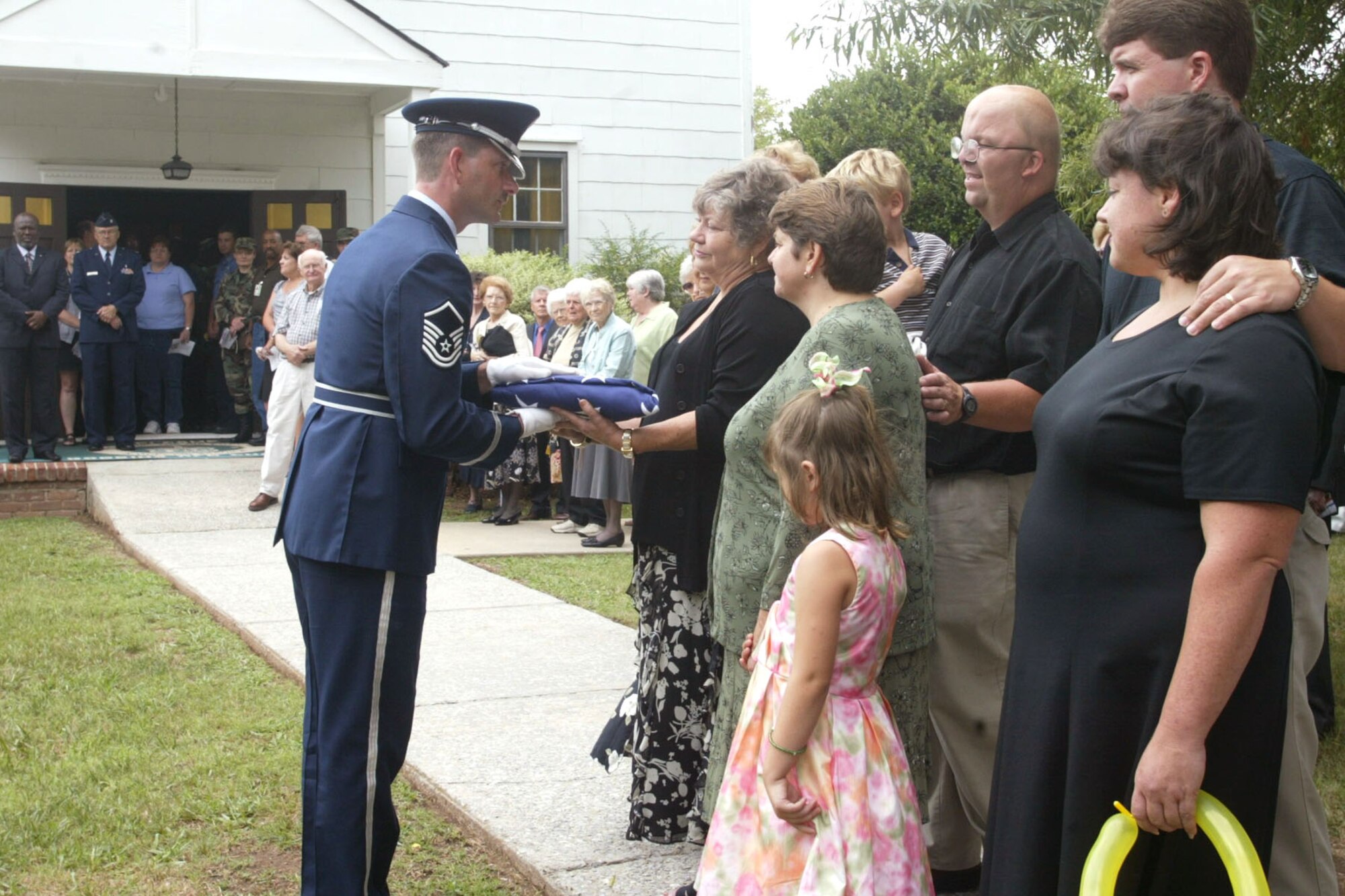 Master Sgt. Bruce See, Honor Guard Superintendant at Dobbins ARB and ceremonial guardsman, offers a folded United Stated flag in condolence during a funeral at an honor guard ceremony. Sgt. See is retiring after 20 years of service in the United States Air Force.  From 2005 to 2011, Sgt. See held the title of Honor Guard Superintendant.  (U.S. Air Force photo/ Don Peek)