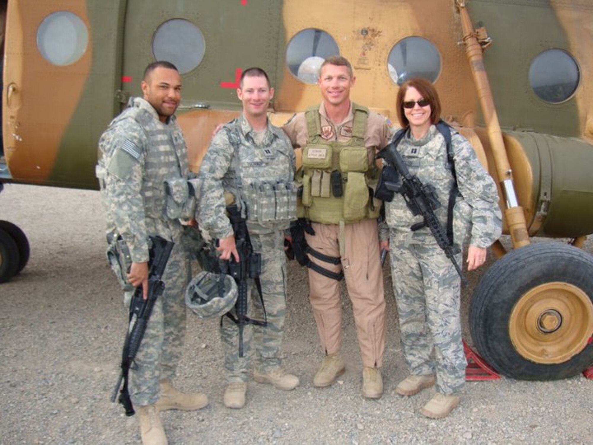 Capt. Brent Tschikof (second from left), assigned to the 830th Air Expeditionary Advisory Group, with other air advisors in front of a MI-17 helicopter while deployed to Afghanistan. (Courtesy photo)