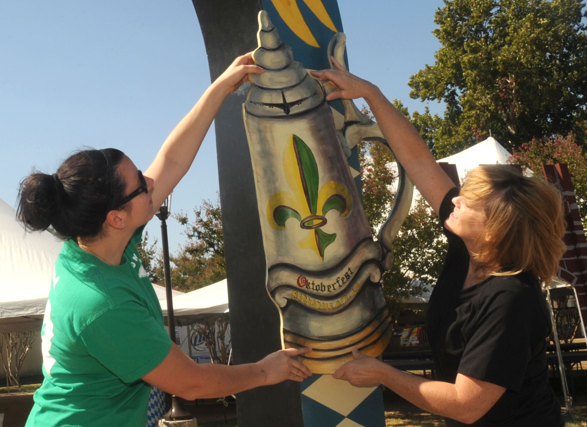 Katie Lund and Kye Quesinberry, members of the Barksdale Officers Spouses Club, hang a wooden beer stein on an archway during setup for the Oktoberfest celebration at the Barksdale Consolidated Club on Barksdale Air Force Base, La., Sept. 30. The annual celebration was started in 2007 by retired Col. West Anderson, former 2nd Bomb Wing vice commander and is the base's largest morale event. (U.S. Air Force photo/Senior Airman Kristin High)(RELEASED)