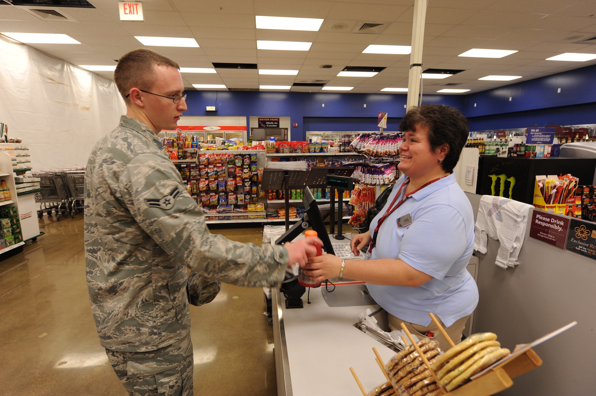 U.S. Air Force Airman 1st Class Nicholas Hughes, 28th Operational Weather Squadron technician, pays Juanita Viens, Army and Air Force Exchange Service shoppette employee, Shaw Air Force Base, S.C., Sept. 29, 2011. They are in the newly renovated part of the building. The end results will be able to handle the growing population of Shaw, faster service and a greater capacity for goods.  (U.S. Air Force photo by Airman 1st Class Neil D. Warner/Released)