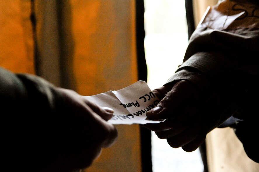 An Airman hands off his accountability card upon entering a building during a phase II operational readiness exercise at Moody Air Force Base, Ga., Sept. 28, 2011. All personnel relinquished their card upon entering a new building and picked it up as they left. The exercise was the first to use to new accountability card concept geared to ensure 100 percent accountability of personnel. (U.S. Air Force Photo by Staff Sgt. Joshua Garcia/Released) 