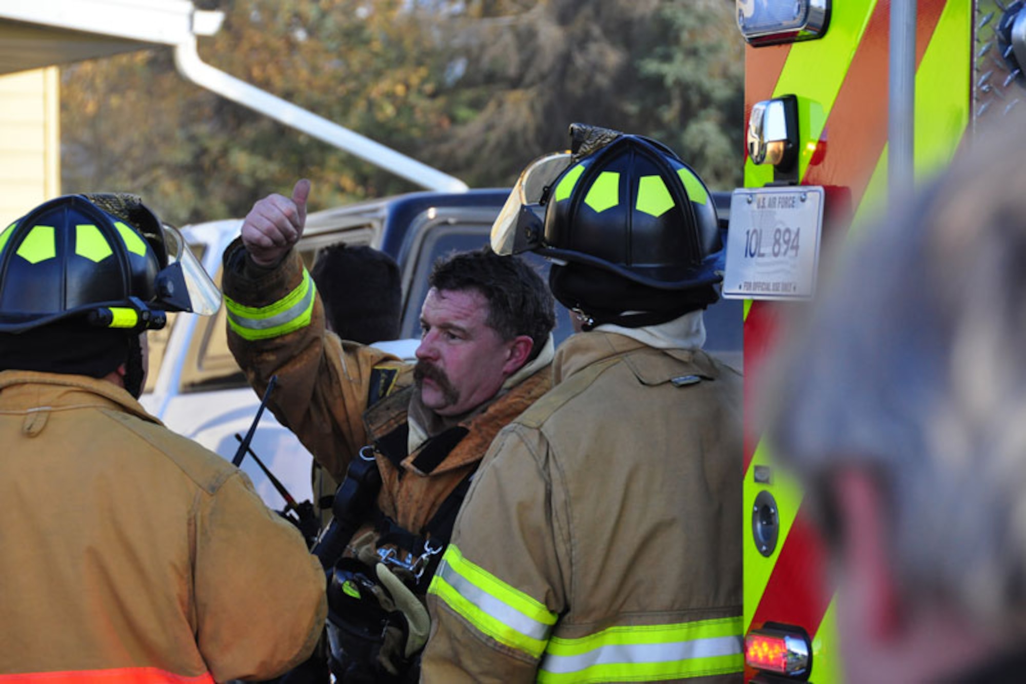 JBER firefighter Mr. Kirk Gibbs offers a thumbs up after emerging from a house fire, Wednesday. (U.S. Air Force photo/Maj. Joseph Coslett)