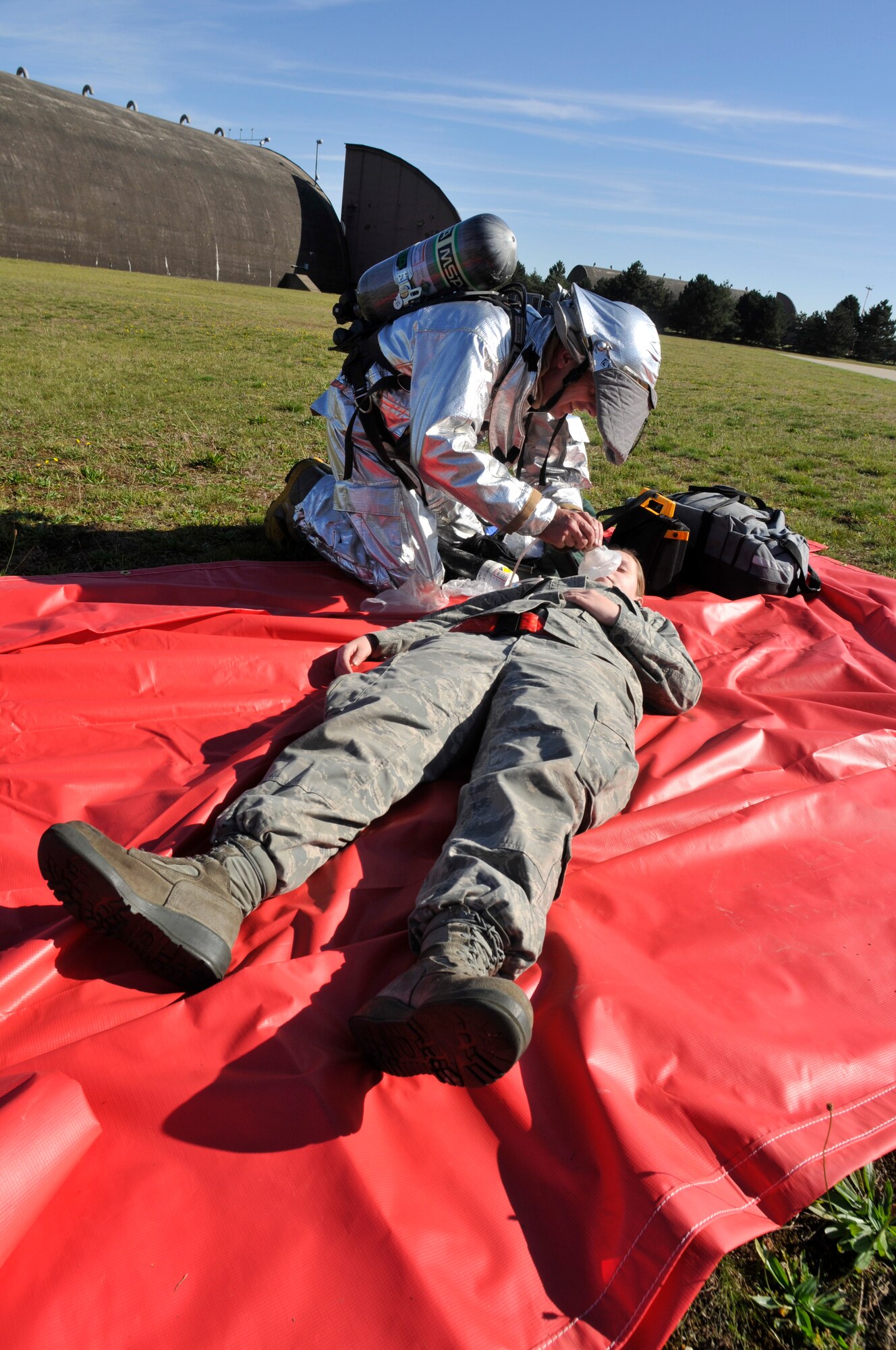 ROYAL AIR FORCE LAKENHEATH, England - Nigel Rust, 48th Civil Engineer Squadron Ministry of Defence firefighter, places a breathing mask on Airman 1st Class Ashton Colburn, 48th Aircraft Maintenance Squadron weapons load crew member, during an exercise, Sept. 27, 2011. The 48th CES firefighters train routinely to remain proficient and ready to respond to emergencies. (U.S. Air Force photo by Senior Airman Tiffany M. Deuel)