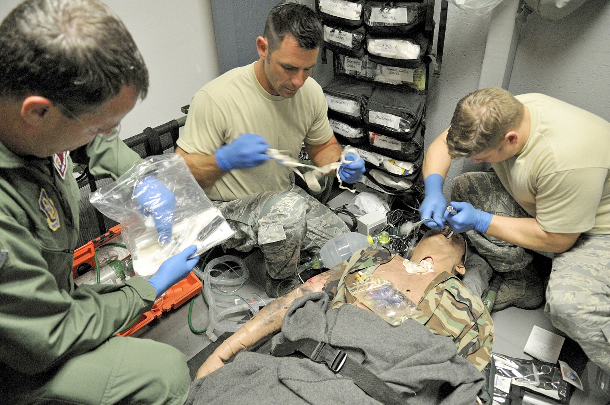 PATRICK AIR FORCE BASE, Fla. - 920th Rescue Wing Combat Search and Rescue Medical Elements team, Lt. Col. Thomas Majcher, Master Sgt. Robert Carcieri, and Tech. Sgt. Mike Braley perform resuscitation procedures on a mannequin in the HH-60G Pave Hawk helicopter simulator. The simulator allows Pararescuemen and CSARME to practice performing medical procedures in the small, cramped environment inside the helicopter. The lights can be dimmed and loud audio noise can be played to realistically portray the difficult working conditions. (U.S. Air Force photo/ Master Sgt. John Schiller)