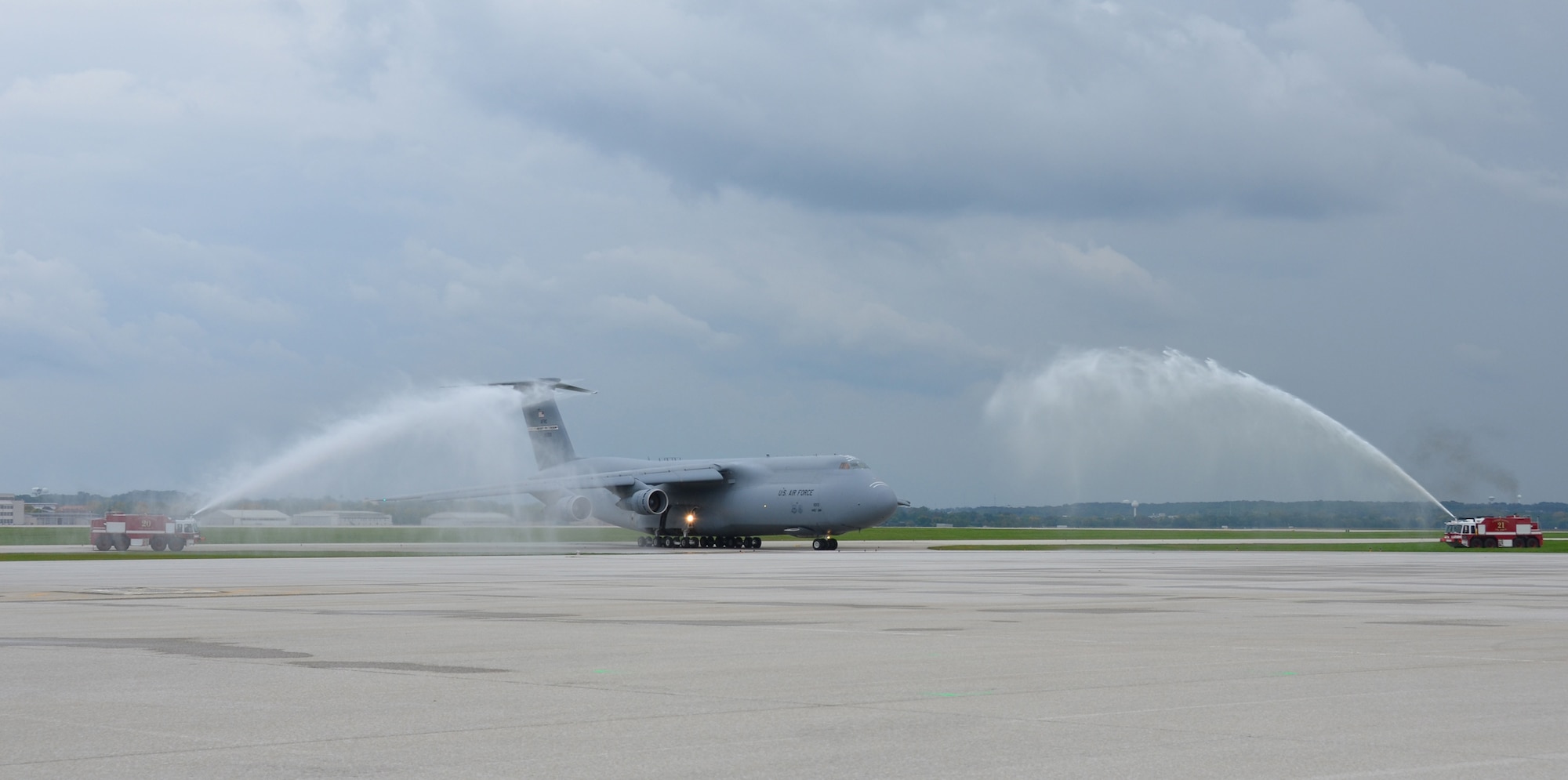 WRIGHT-PATTERSON AIR FORCE BASE, Ohio – Two Wright-Patt fire trucks flank the C-5 Galaxy and give it a water cannon salute after the plane’s final mission here Sept. 28. C-5’s have been assigned to the 445th Airlift Wing since 2005 and are being replaced by the C-17 Globemaster III. (U.S. Air Force photo/Staff Sgt. Robert Nelson)