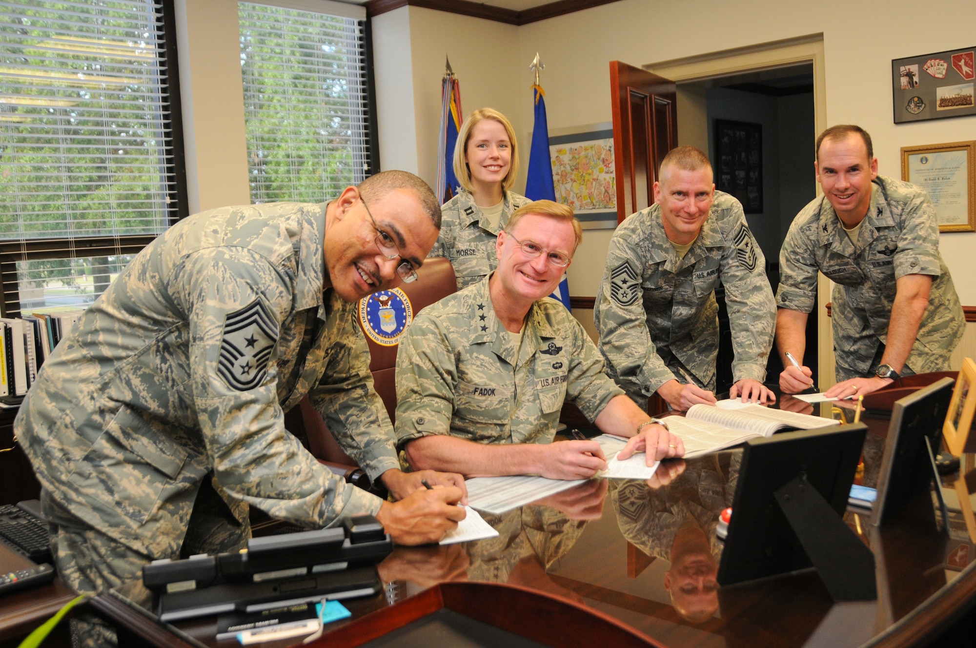From left, Chief Master Sgt. Lonnie Slater, Air University command chief; Capt. Paula Morse, Maxwell installation project officer; Lt. Gen. David Fadok, Air University commander and president; Chief Master Sgt. Jeffrey Wepner, 42nd Air Base Wing command chief; and Col. Brian Killough, 42nd Air Base Wing commander, sign pledge forms during the Combined Federal Campaign kickoff event Sept. 22 at the officers’ club. (Air Force photo/Chris Baldwin)