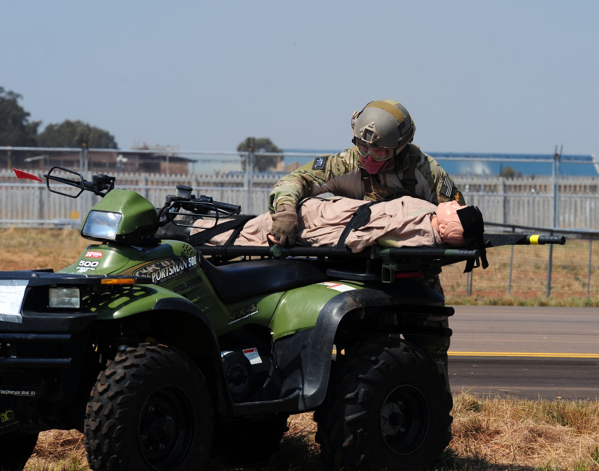 Pretoria, South Africa -- Senior Master Sgt. Jeff Baker, Guardian Angel assigned to the 103rd Rescue Squadron, Gabreski Airport, New York, straps a simulated casualty to an all terrain vehicle as part of the 2011 Air show & Lifestyle Expo practice at Waterkloof Air Force Base, Sept. 29, 2011. Moments before both Sergeant Baker and the ATV were dropped out of an U.S. Air Force HC-130 as it passed by the air field. (U.S. Air Force photo by Tech. Sgt. Todd Wivell)