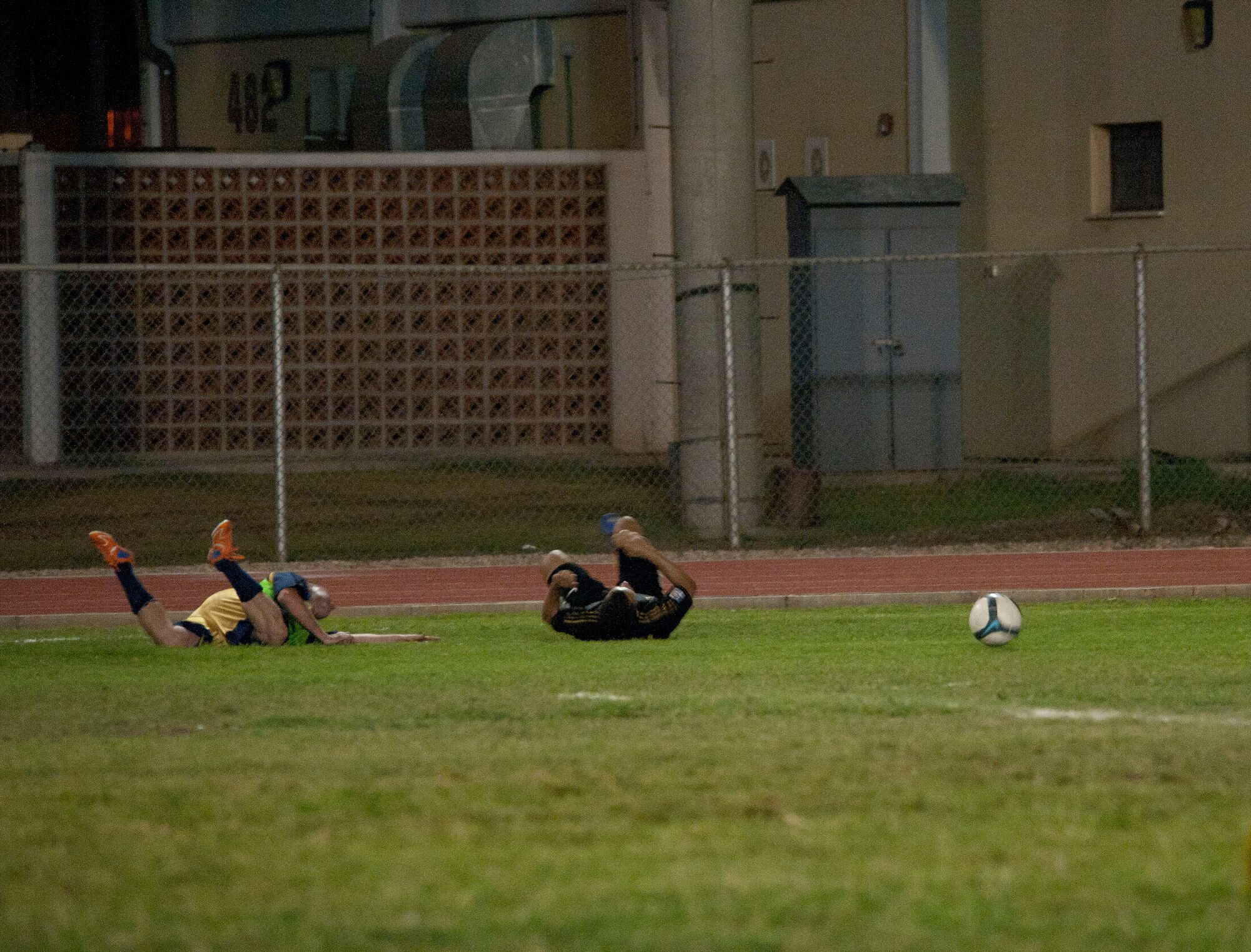 Two players tumble to the ground after colliding during the intramural soccer championship game Sept. 29, 2011, at Incirlik Air Base, Turkey. The 728th Air Mobility Squadron won against the 39th Security Forces Squadron 3-1. (U.S. Air Force photo by Senior Airman Clayton Lenhardt/Released)