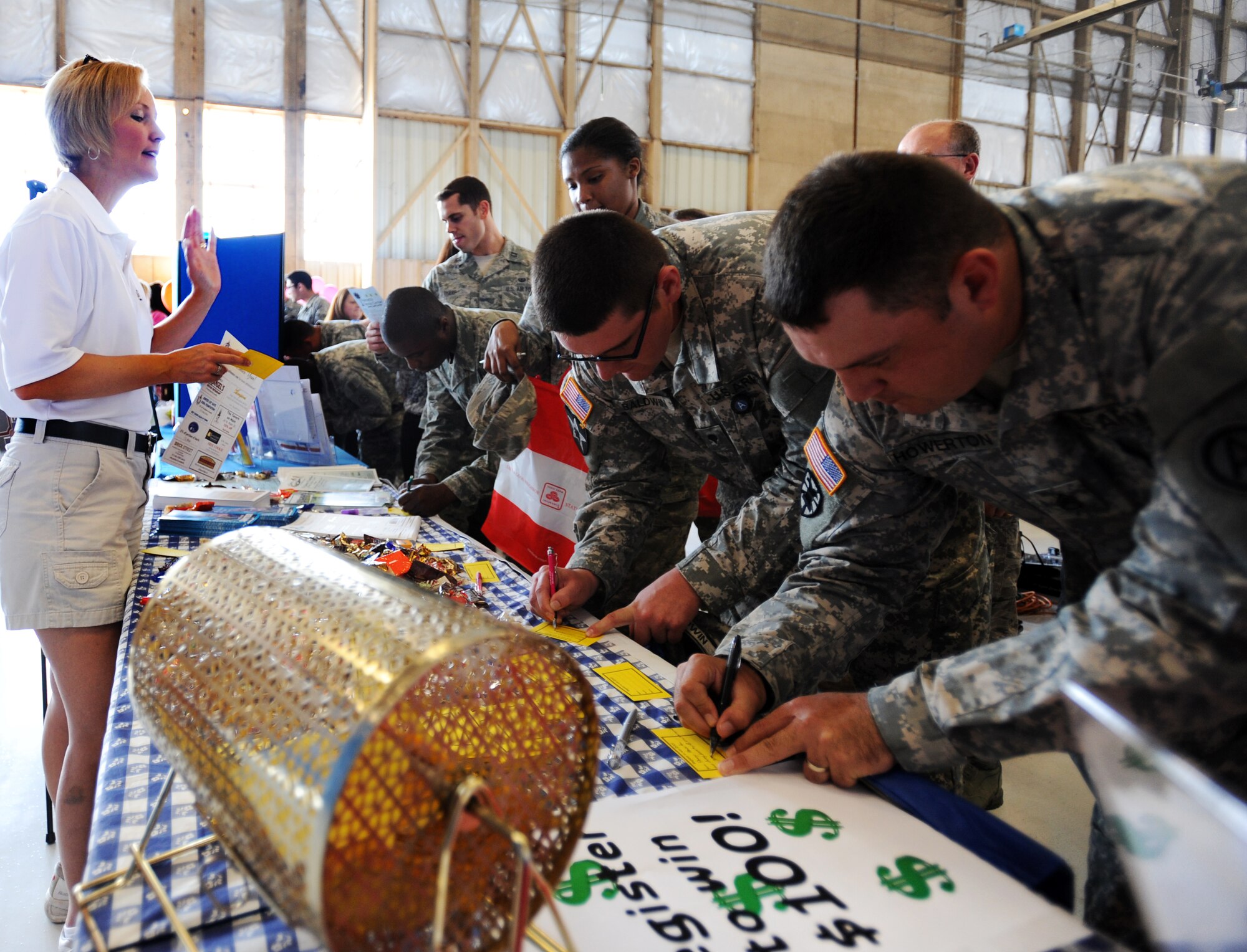 U.S. Army Soldiers and U.S. Air Force Airmen fill out information for a drawing at one of the vender tables during Military Appreciation Picnic, Shaw Air Force Base, S.C., Sept. 29, 2011. It was the third annual picnic organized by the Sumter Chamber of Commerce's military affairs committee. Approximately 200 volunteers participated. (U.S. Air Force photo by Airman 1st Class Tabatha Duarte/Released)