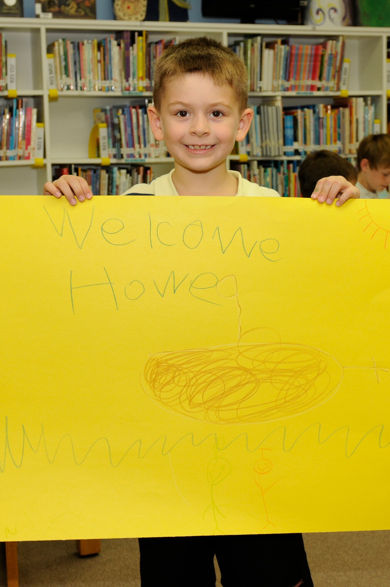 SPANGDAHLEM AIR BASE, Germany -- Trace Adcock, son of Staff Sgt. Joshua Adcock, 52nd Aircraft Maintenance Squadron, holds a welcome home poster he decorated for his dad during Deployment Club at the Spangdahlem Elementary School Sept. 28. The Deployment Club is an after-school event held monthly while school is in session. It allows children whose parents are deployed to cope and navigate the many unique situations they may face. The children decorate posters, color pictures and talk with each other about their experiences. (U.S. Air Force photo/Airman 1st Class Brittney Frees)