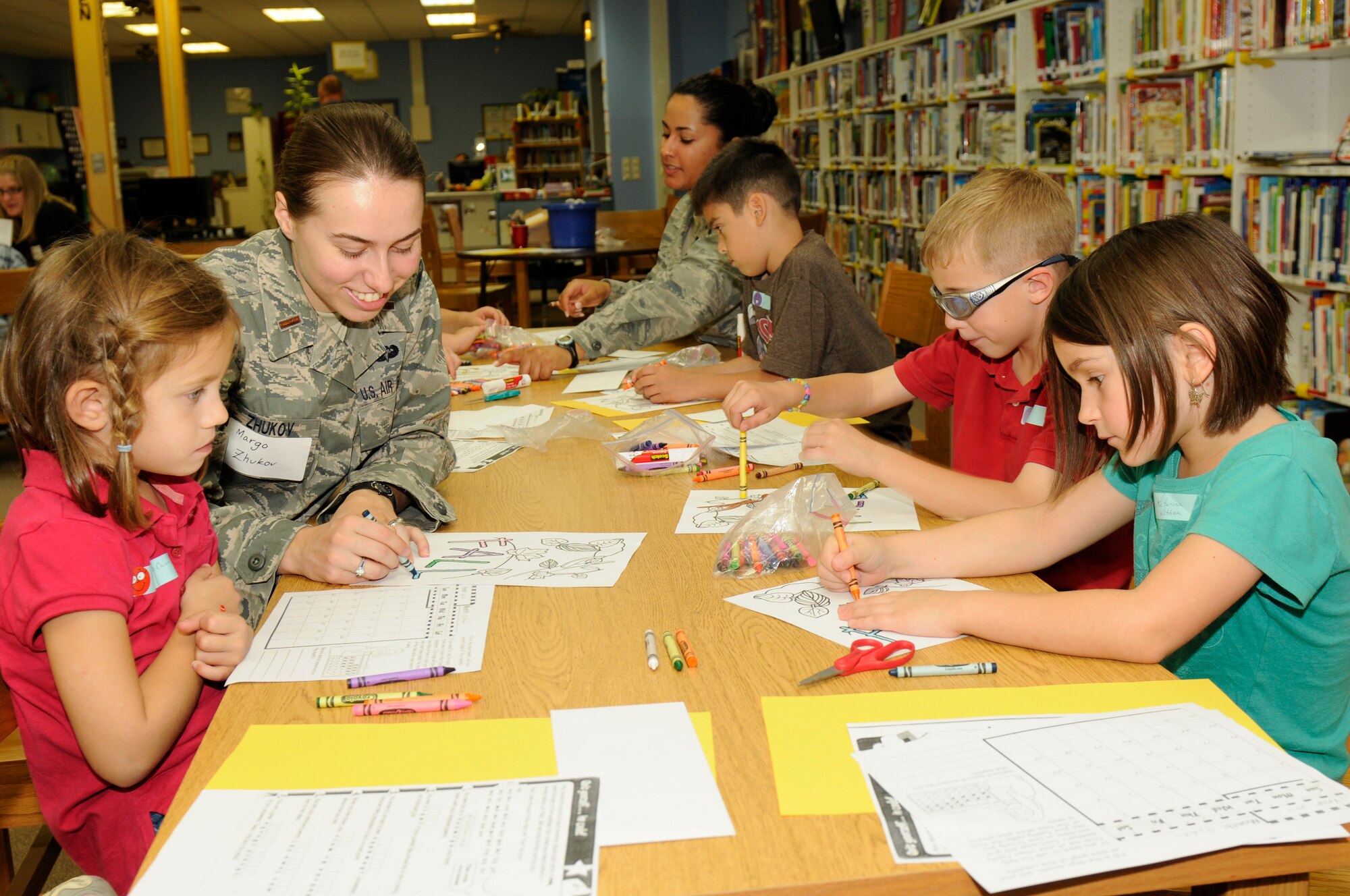 SPANGDAHLEM AIR BASE, Germany -- Second Lt. Margo Zhukov, 726th Aircraft Maintenance Squadron cargo officer, colors with children from Spangdahlem Elementary School during Deployment Club here Sept. 28. The Deployment Club is an after-school event held monthly while school is in session. It allows children whose parents are deployed to cope and navigate the many unique situations they may face. The children decorate posters, color pictures and talk with each other about their experiences. (U.S. Air Force photo/Airman 1st Class Brittney Frees)