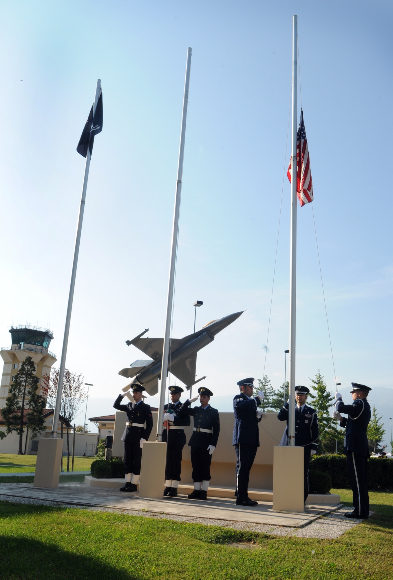 Aviano Air Base Honor Guard members lower the American flag as Italian air force Airmen stand by during a POW/MIA retreat ceremony Sept. 29 at the 31st Fighter Wing Headquarters. Team Aviano hosted a series of activities to honor the prisoners of war and missing in action. (U.S. Air Force photo/Staff Sgt. Julius Delos Reyes)
