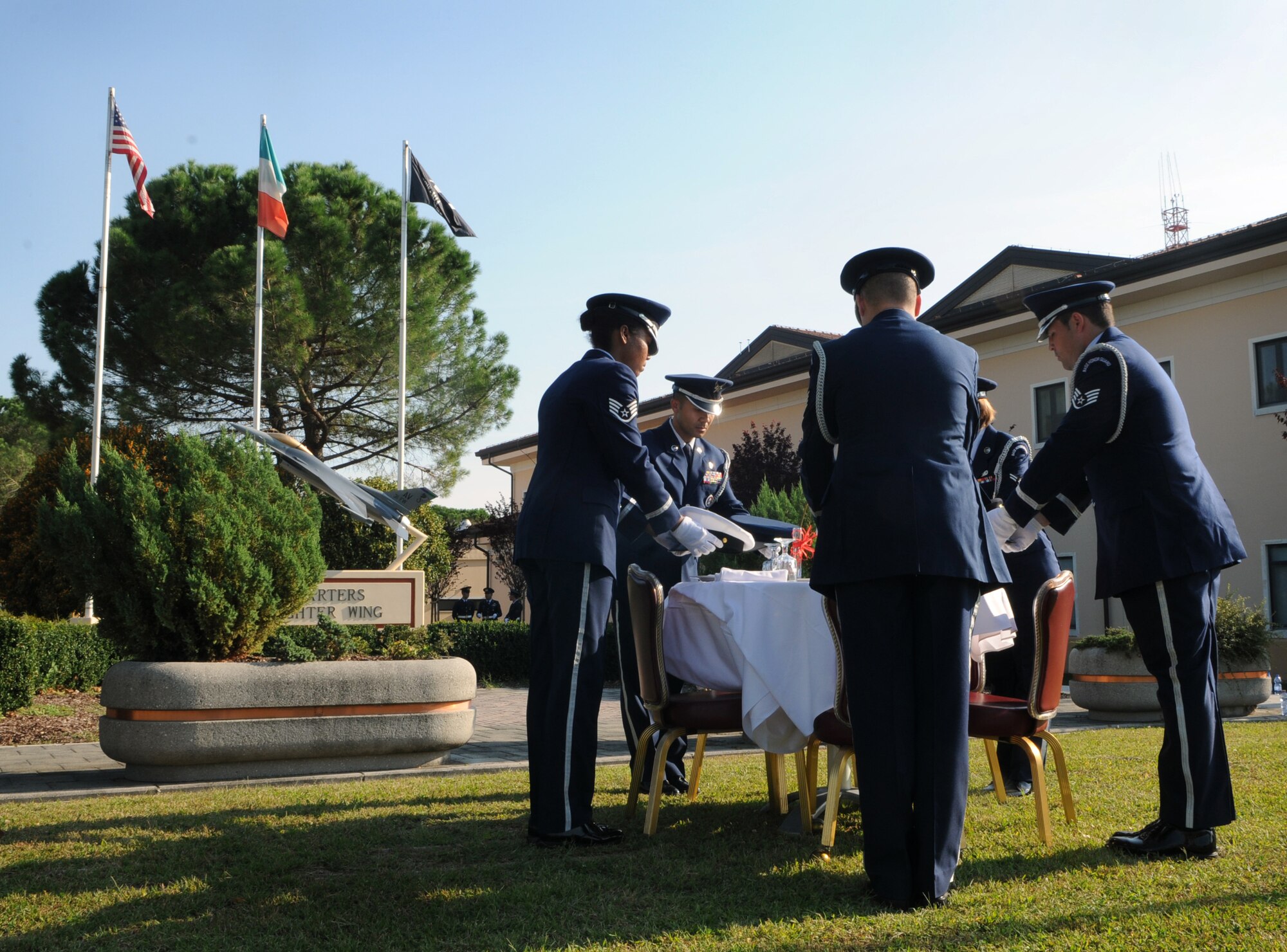 Aviano Air Base Honor Guard members lay down the five services hats as part of POW/MIA table ceremony Sept. 29 at the 31st Fighter Wing Headquarters. During the week, Team Aviano hosted a series of activities as part of the POW/MIA commemoration. Service members, civilians and dependents held a 24-hour vigil run Sept. 27-28. Volunteers also read the names of prisoners of war and those who are still missing in action. (U.S. Air Force photo/Staff Sgt. Julius Delos Reyes)