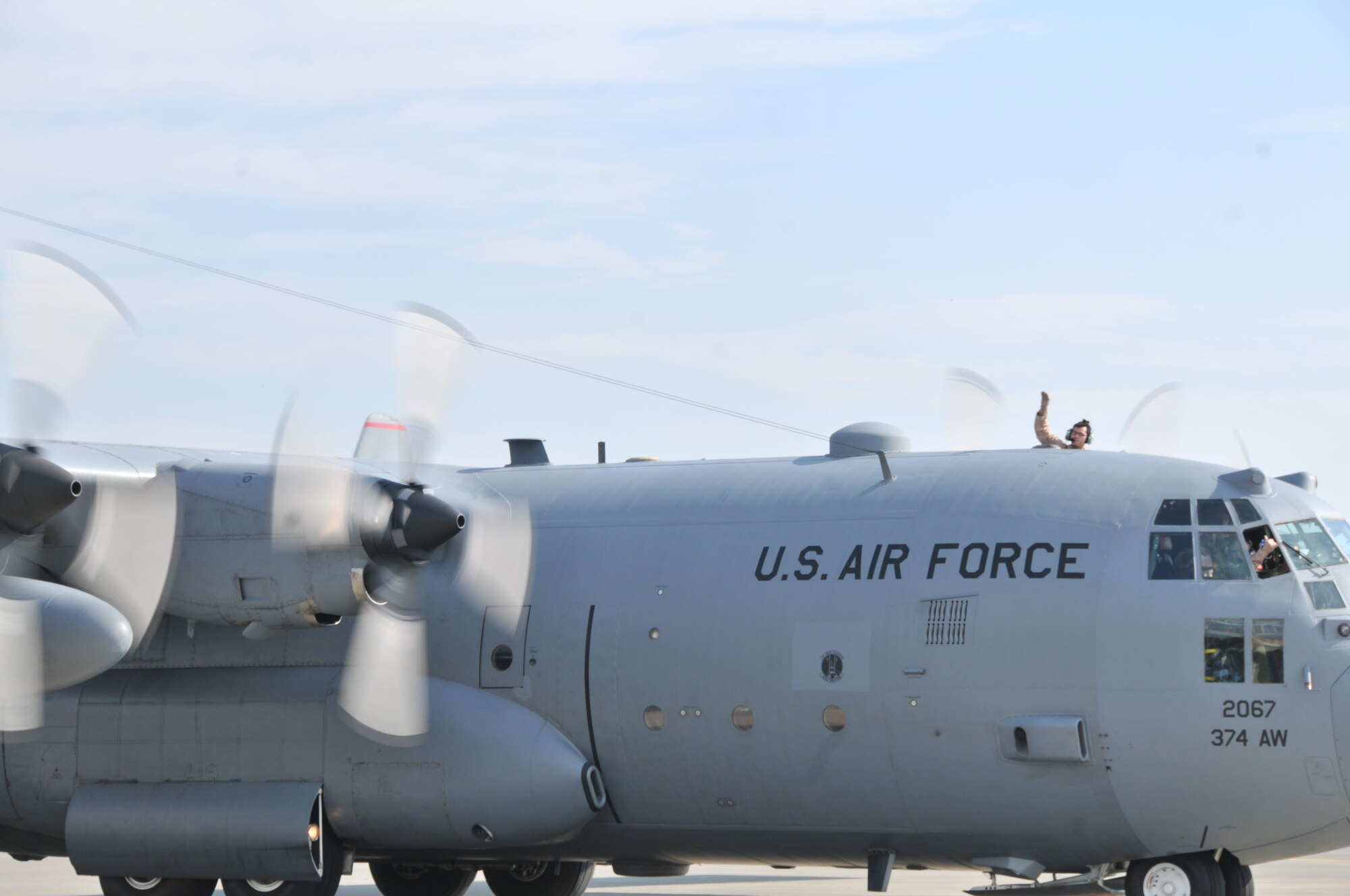 YOKOTA AIR BASE, Japan -- A crew from the 36th Airlift Squadron waves goodbye from their C-130 Hercules to family and squadron members Sept. 30, 2011, at Yokota Air Base, Japan. The crew, headed for deployment throughout Southwest Asia, will be deployed for several months. (U.S. Air Force photo/Airman 1st Class Desiree Economides)