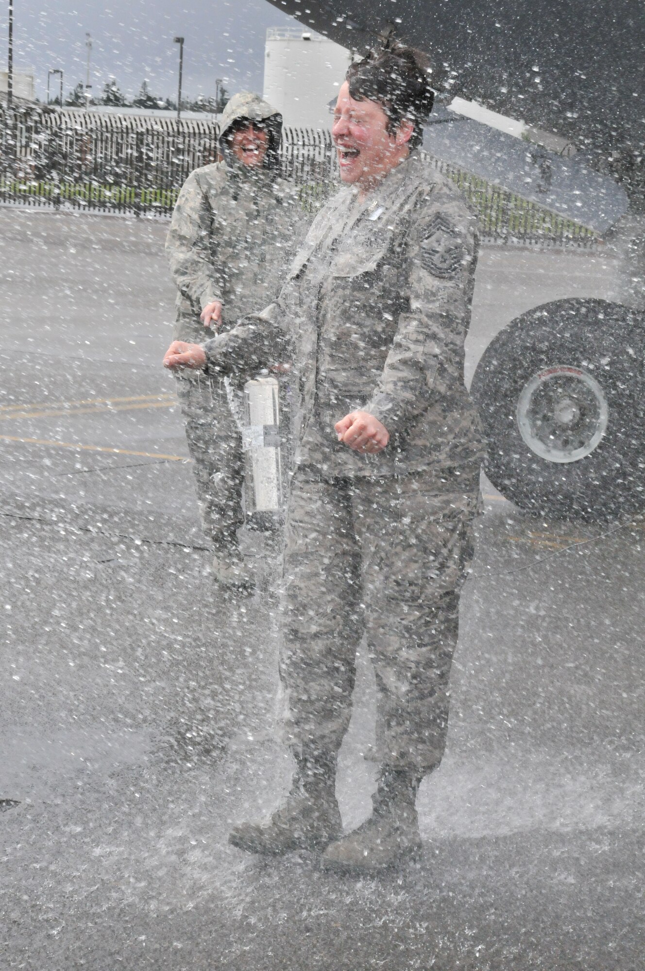Command Chief Master Sgt. Gloria Bennett, 446th Airlfit Wing, gets soaked as her family and friends celebrate her final flight in a C-17 Globemaster III at McChord Field March 30.  Bennett is retiring after 33 years of service in the Air Force Reserve. "During my career, supervisors gave me numerous opportunities to particpate in taskings, activities, and events outside my normal duties.  It was not until much later in my career that I figured out these 'voluntold' opportunities helped to broaden my experience and knowledge. Now 33 years later, I can look back on the wonderful friendships built and memories shared with the hardest working, best-looking, and most talented Reservists in the Air Force Reserve Command.  Thank you for being a part of my life," said Bennett.  (U.S. Air Force photo by 2nd Lt. Denise Hauser)