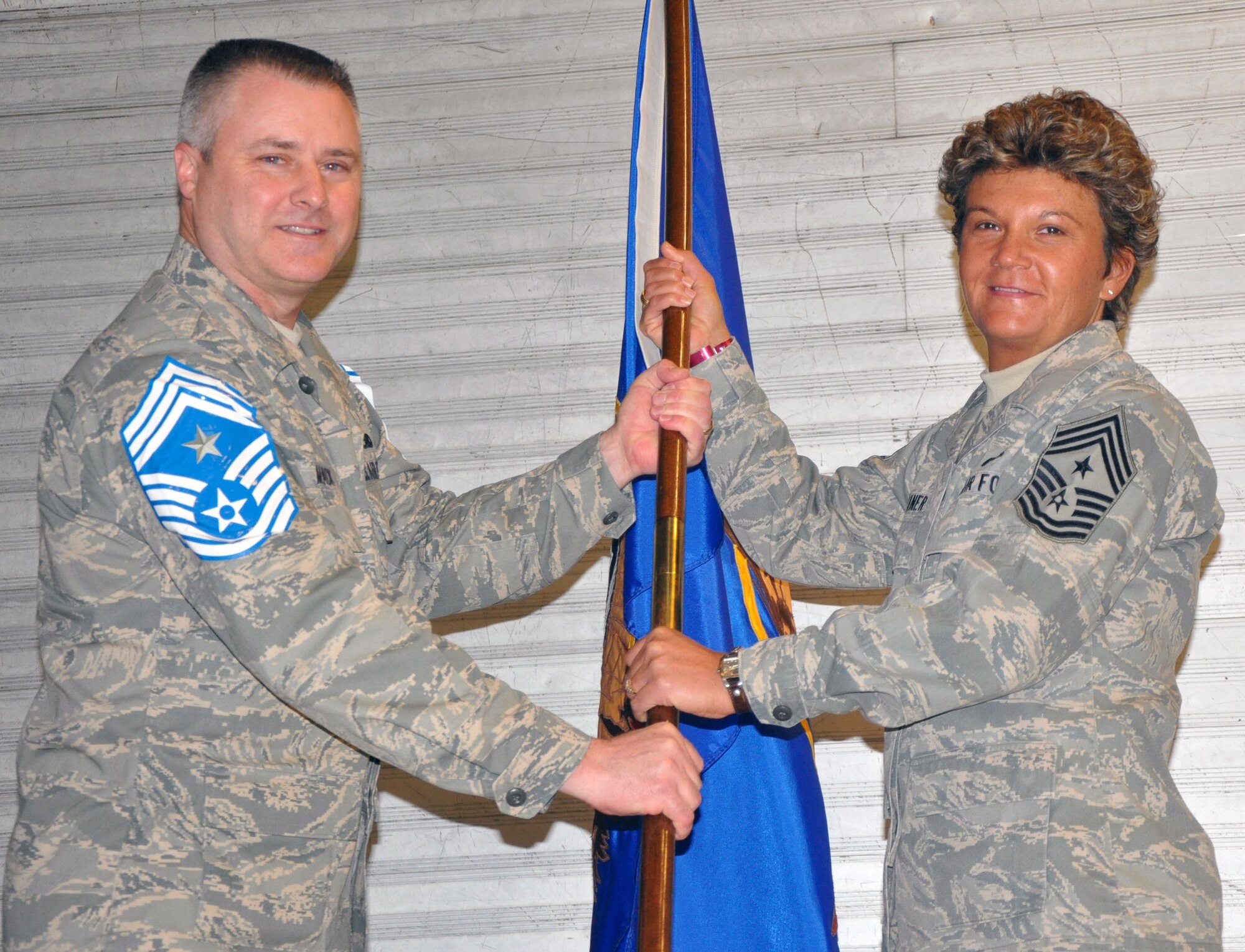 MCCHORD FIELD, Wash. - Chief Master Sgt. Anthony Mack, 446th Airlift Wing command chief presents a chief's flag to Chief Master Sgt. Kathleen Buckner, Air Force Reserve Command, command chief, during the 446th AW commander's call here.  Mack received his stripe and was appointed to 446th AW command chief during the ceremony April 1 at Hangar 9.  (U.S. Air Force photo by Tech. Sgt. Eizabeth Moody)