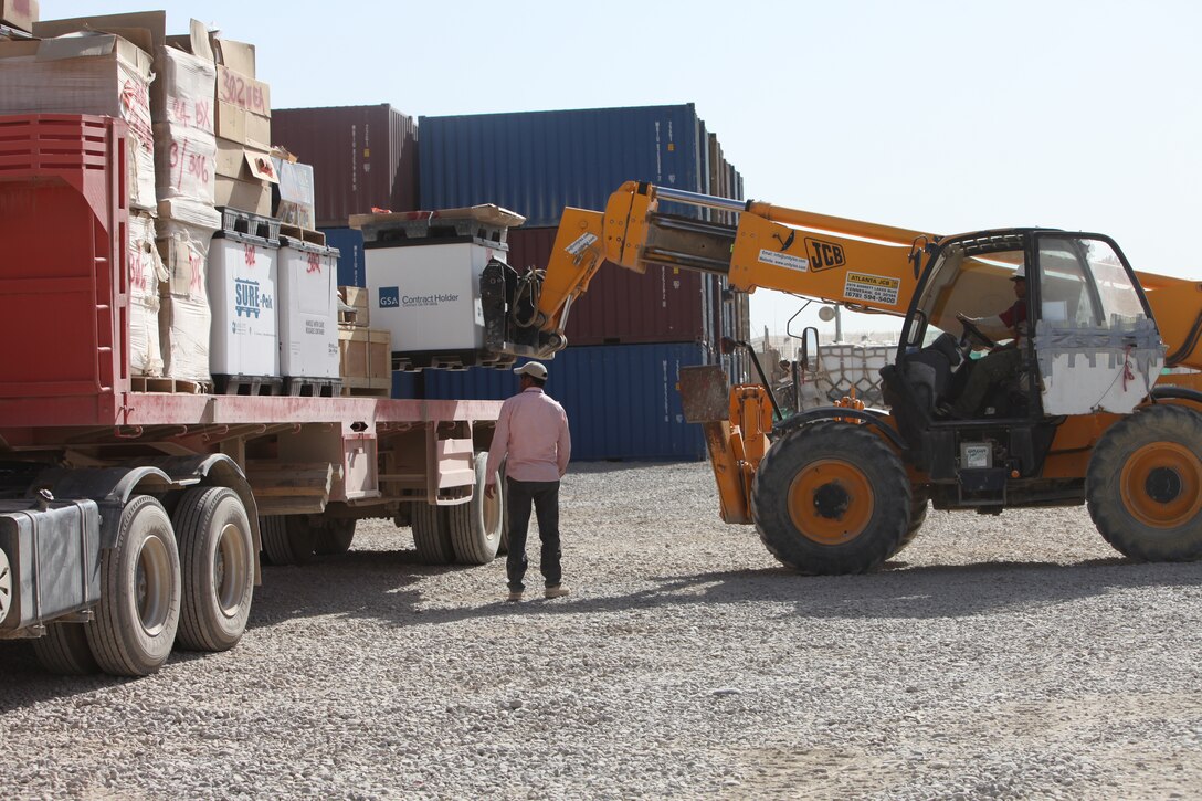 At the Supply Management Unit lot at Camp Leatherneck, Afghanistan, third country nationals assist with the moving and shipping of supply items in Regional Command Southwest. Marines with the SMU, Marine Air-Ground Task Force Support Battalion 11.2, 1st Marine Logistics Group (Forward) support 75 Marine Corps units in the region and the lot contains 17 acres of supply assets. While they act as a massive warehouse for supply items, the SMU has played a significant role in the retrograde as well.