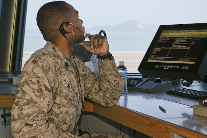 Staff Sgt. Xavier W. Wethington, Headquarters and Headquarters Squadron local controller trainee, watches over controls and plans which aircraft will have priority to the runways from the air traffic control tower here April 2. The air traffic control tower’s main goal is to keep the air station running smoothly while allowing military aircraft to use the runways as often as possible.