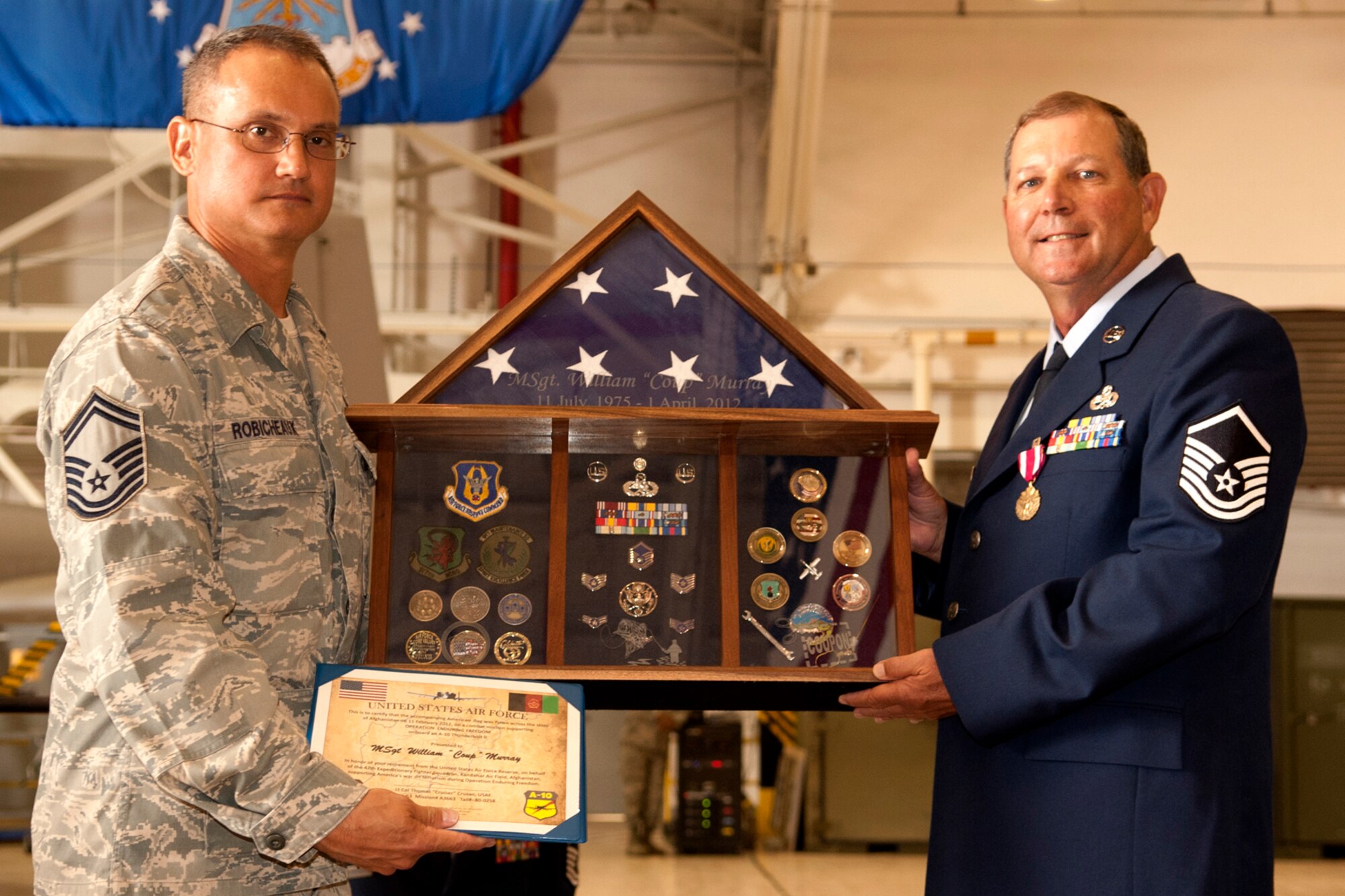 U.S. Senior Master Sgt. Stephen Robicheaux, 917th Maintenance Squadron, presents a shadow box to Master Sgt. William Murray during a retirement ceremony at Barksdale Air Force Base, La., April 1, 2012. Murray is retiring from the Air Force Reserve with more than 30 years of service. (U.S. Air Force photo by Master Sgt. Greg Steele/Released)