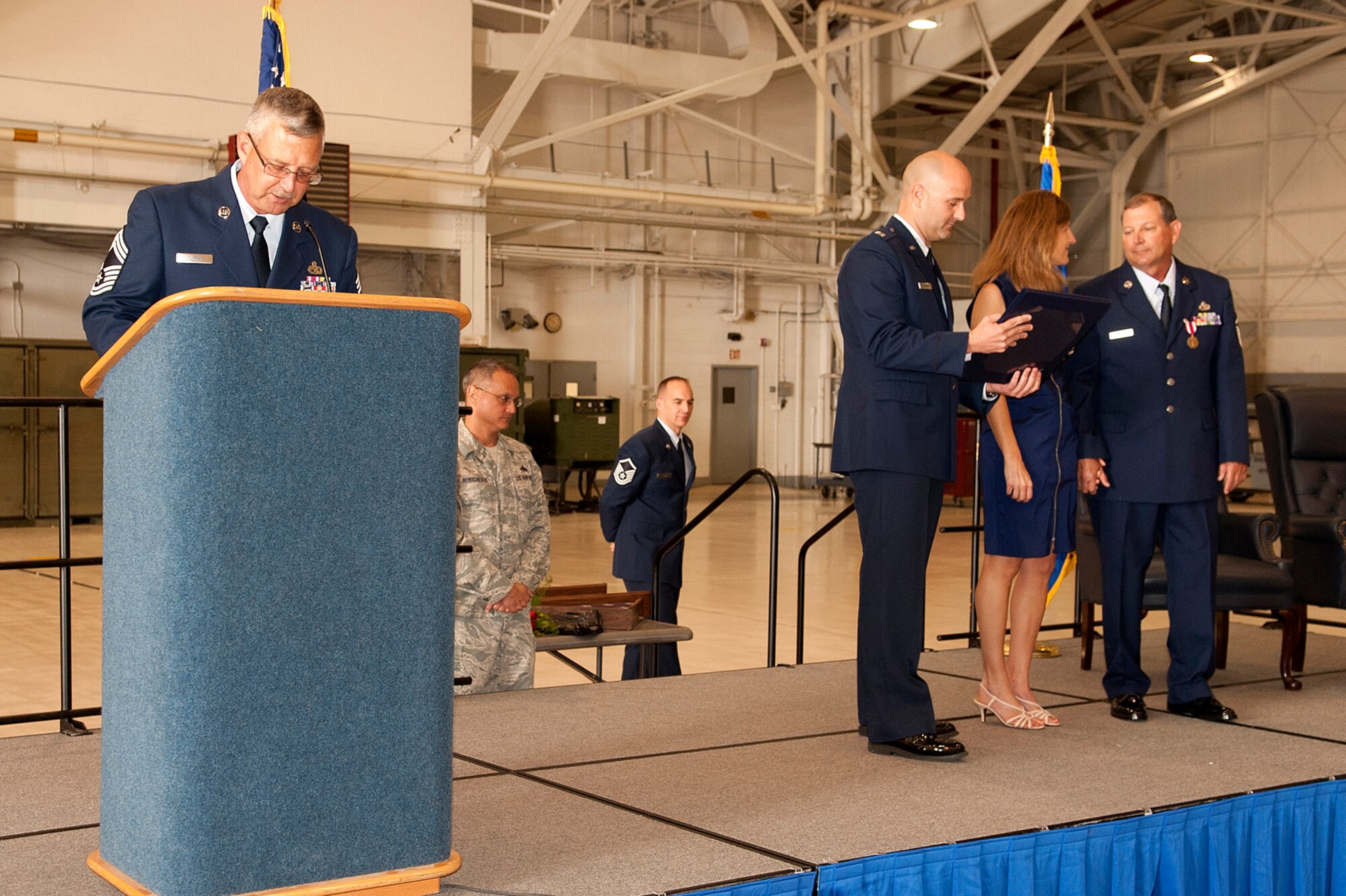 U.S. Air Force Chief Master Sgt. Robert Murray, 307th Maintenance Squadron superintendent, reads the spouse appreciation certificate as it is presented to Marcy, the wife of retiring Master Sgt. William Murray, during a retirement ceremony at Barksdale Air Force Base, La., April 1, 2012. Brothers Robert and William Murray served together for almost 30 years at Barksdale. (U.S. Air Force photo by Master Sgt. Greg Steele/Released)