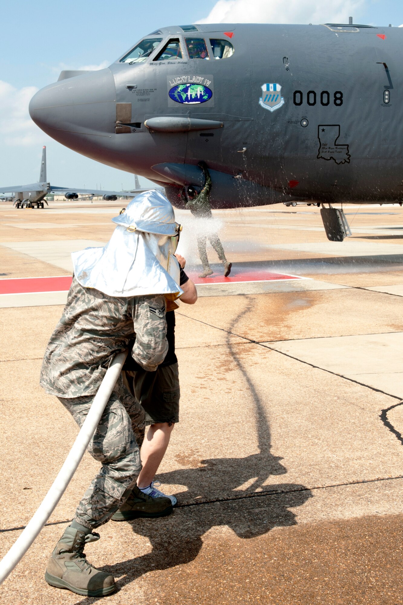 A U.S. Air Force fireman helps Sandy Rodriguez hose down her husband, U.S. Air Force Lt. Col. Rafael Rodriguez, 343rd Bomb Squadron navigator, as he plants a kiss on the B-52 he just took his final flight in at Barksdale Air Force Base, La., March 31, 2012. Rodriguez is retiring from the Air Force Reserve and has over 5,400 flying hours in the B-52. (U.S. Air Force photo by Master Sgt. Greg Steele/Released)