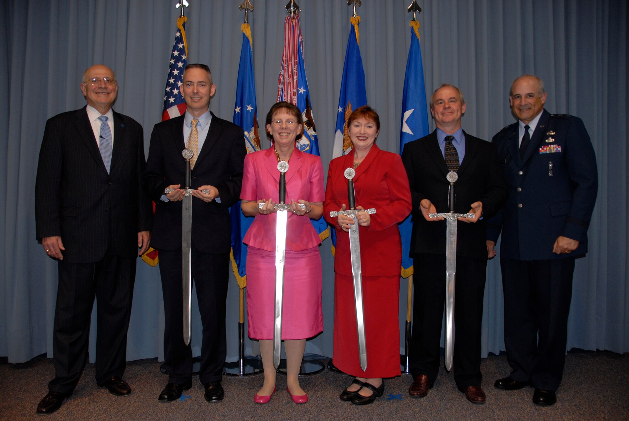 Blaise Durante, the Air Force deputy assistant secretary for acquisition integration (left) and Maj. Gen. Kenneth Merchant, the Air Armament Center commander (right), present the annual Air Armament Academy’s Blaise Durante Instructor of the Year awards April 2 at Eglin Air Force Base, Fla.  The winners were Robbie Norris, for the college of science and technology category (not pictured); Wanda Riley, for the college of acquisition category; Peggy Shepherd, for the college of installation, sustainment and management category; and Jerry Griffith, for the college of test and evaluation category.  The instructors were recognized for their contributions to professional education.  The Air Armament Academy was established in 2003 to ensure Eglin personnel have a wide variety of training opportunities available to promote effectiveness in the workplace.  (U.S. Air Force photo/Kevin Gaddie)