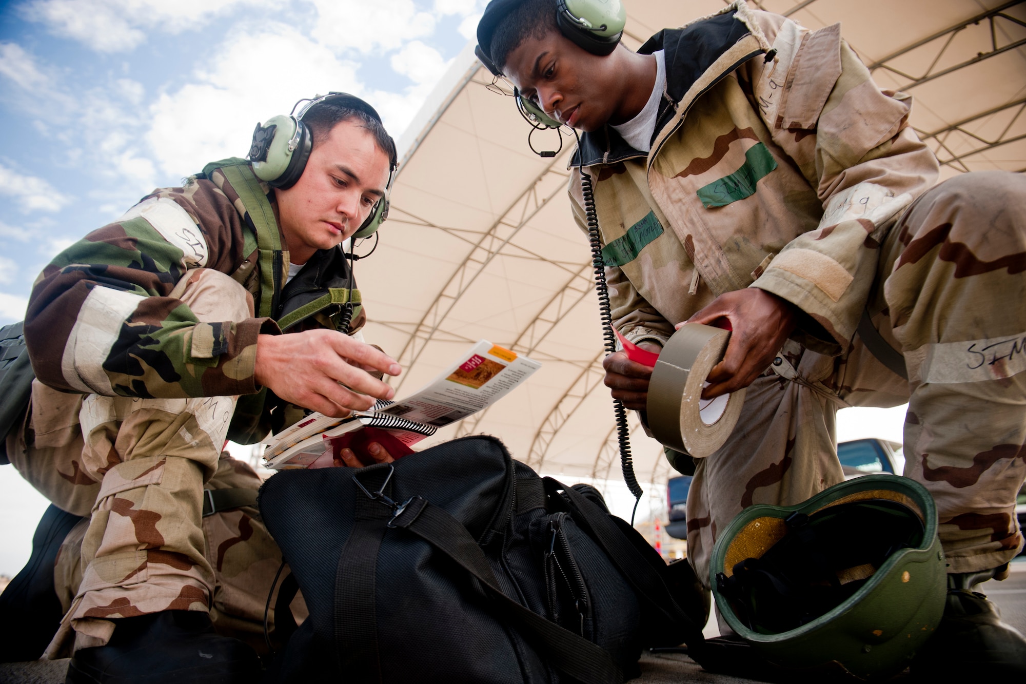 U.S. Air Force Senior Airman Stephen Grenat, 476th Maintenance Squadron, and Airman 1st Class Jontay Motley, 23d Aircraft Maintenance Squadron, review an Airman’s Manual and gather materials in response to a simulated unexploded ordnance situation during a phase II operational readiness inspection at Moody Air Force Base, Ga., March 30, 2012. As part of a post-attack reconnaissance team, Grenat and Motley’s job was to properly mark and report UXO findings to their unit control center. (U.S. Air Force photo by Staff Sgt. Jamal D. Sutter/Released) 