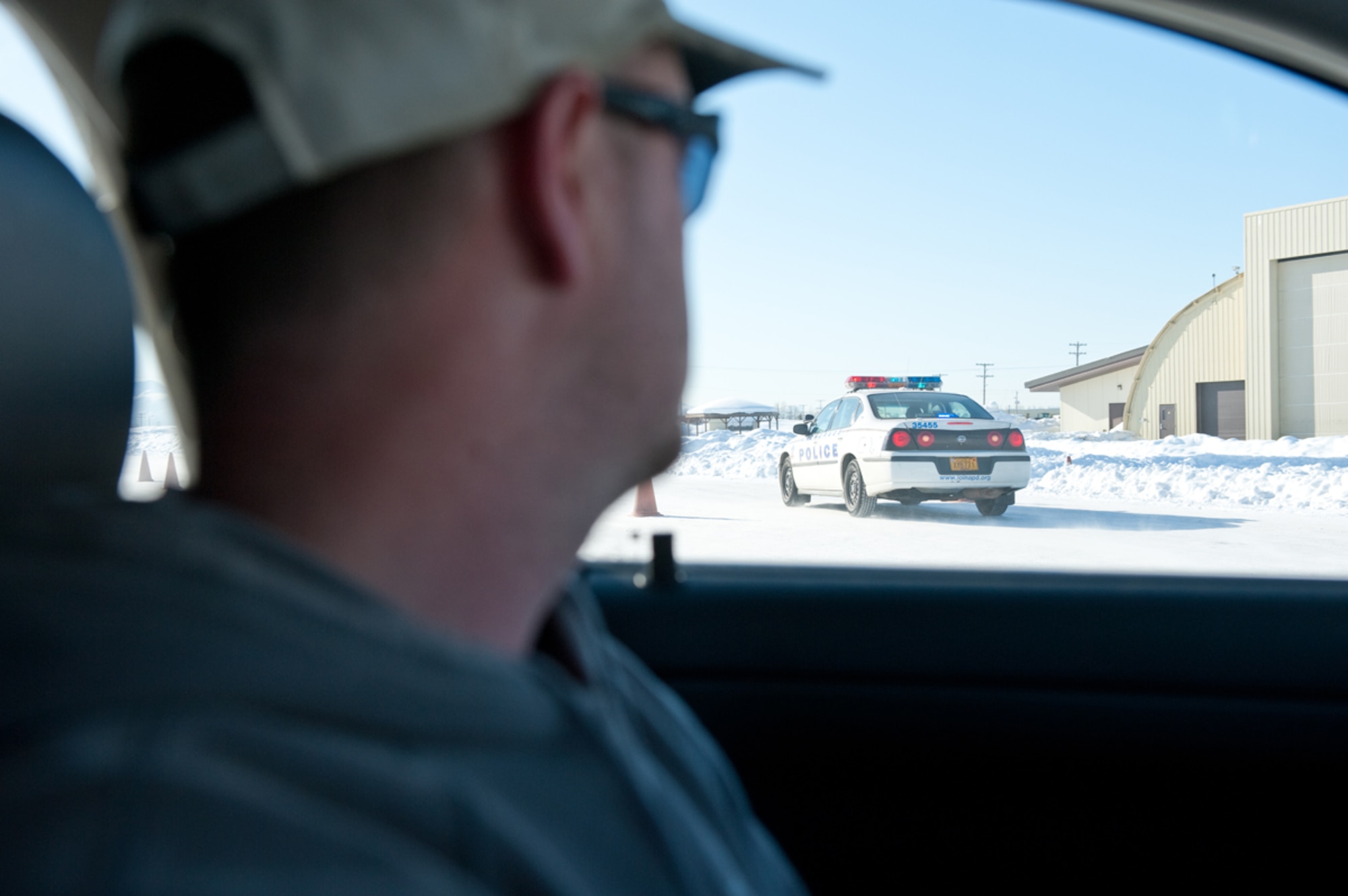 JOINT BASE ELMENDORF-RICHARDSON, Alaska ??? Anchorage Police officer Steven Haas, plays a bad guy during the Anchorage Police Department???s Emergency Vehicle Operations Course March 22. Airman 1st Class Austin Willhoit, 673 Air Base Wing Public Affairs broadcaster, was given the opportunity to play a good guy, and attempt to nab Haas. Haas, a highly trained driver, eluded Willhoit???s pursuit with ease. (U.S. Air Force photo/Johnathon Green)