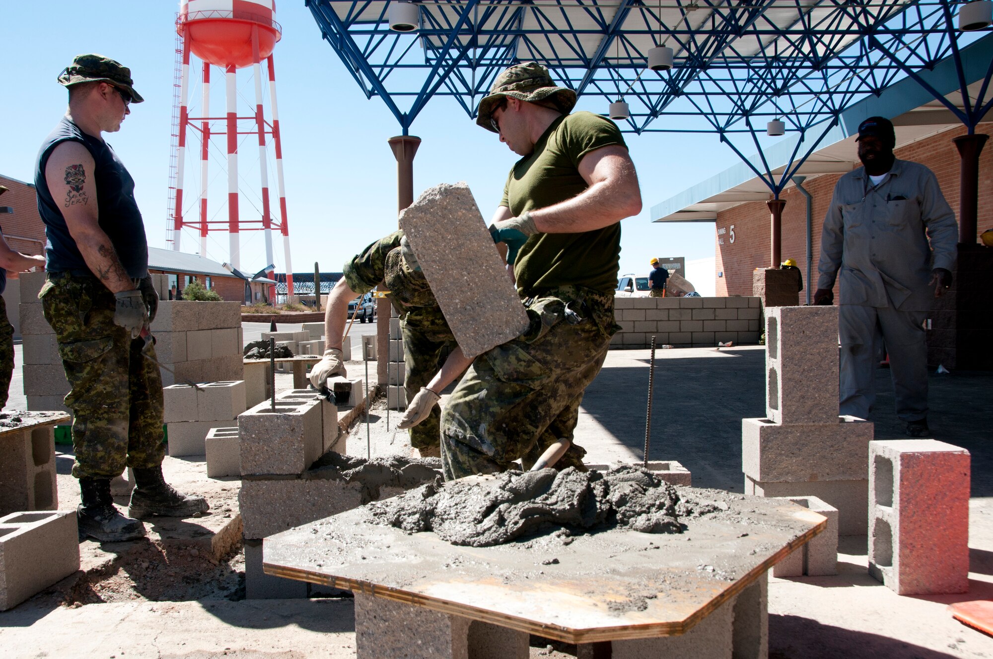 (From the left) Royal Canadian Air Force Cpl. Judd Bettel, Cpl. Darrell Hillier, Cpl. John
Kulczycki, and John Morgan from the 162nd Civil Engineer Squadron, construct a patio wall in front of the 162nd Fighter Wing dining facility March 22. A team of 77 construction engineers from Canada spent the whole month renovating several facilities on base. (U.S. Air Force photo/Master Sgt. Dave Neve)
