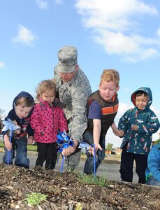 U.S. Air Force Capt. Michael Hayhurst, 633rd Air Base Wing chaplain, helps children plant pinwheels outside the Child Development Center at Langley Air Force Base, Va., April 2, 2012. In celebration of Child Abuse Prevention Month and Month of the Military Child, each child planted a pinwheel, representing a child who deserves to be loved. (U.S. Air Force photo by Staff Sgt. Antoinette Gibson/Released)