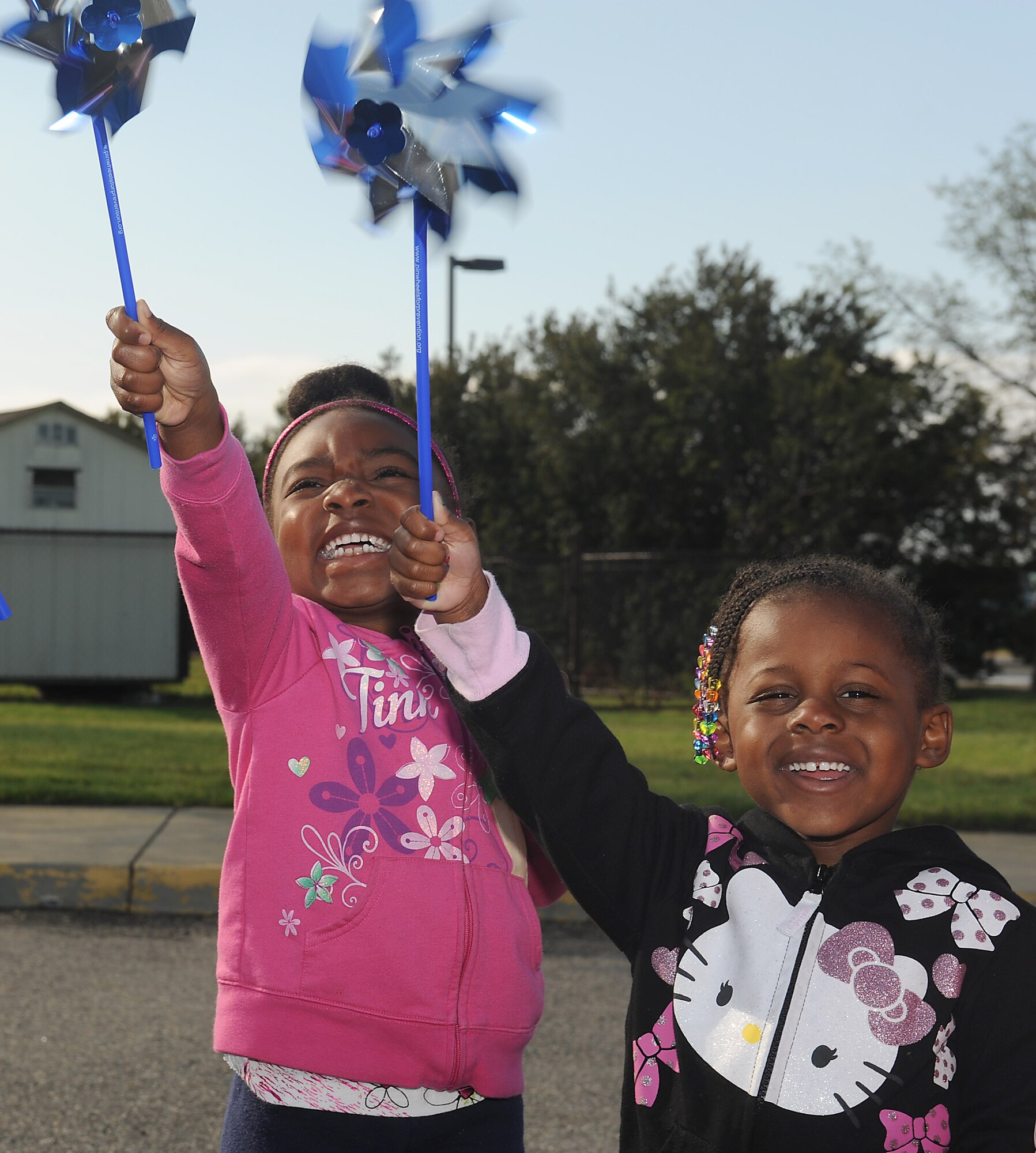 Alona Kinlochk, 5, and Amaya Johnson, 4, play with their pinwheels before planting them outside the Child Development Center at Langley Air Force Base, Va., April 2, 2012. Each pinwheel, planted in celebration of Child Abuse Prevention Month and Month of the Military Child, represents a child that deserves to be loved. (U.S. Air Force photo by Staff Sgt. Antoinette Gibson/Released)
