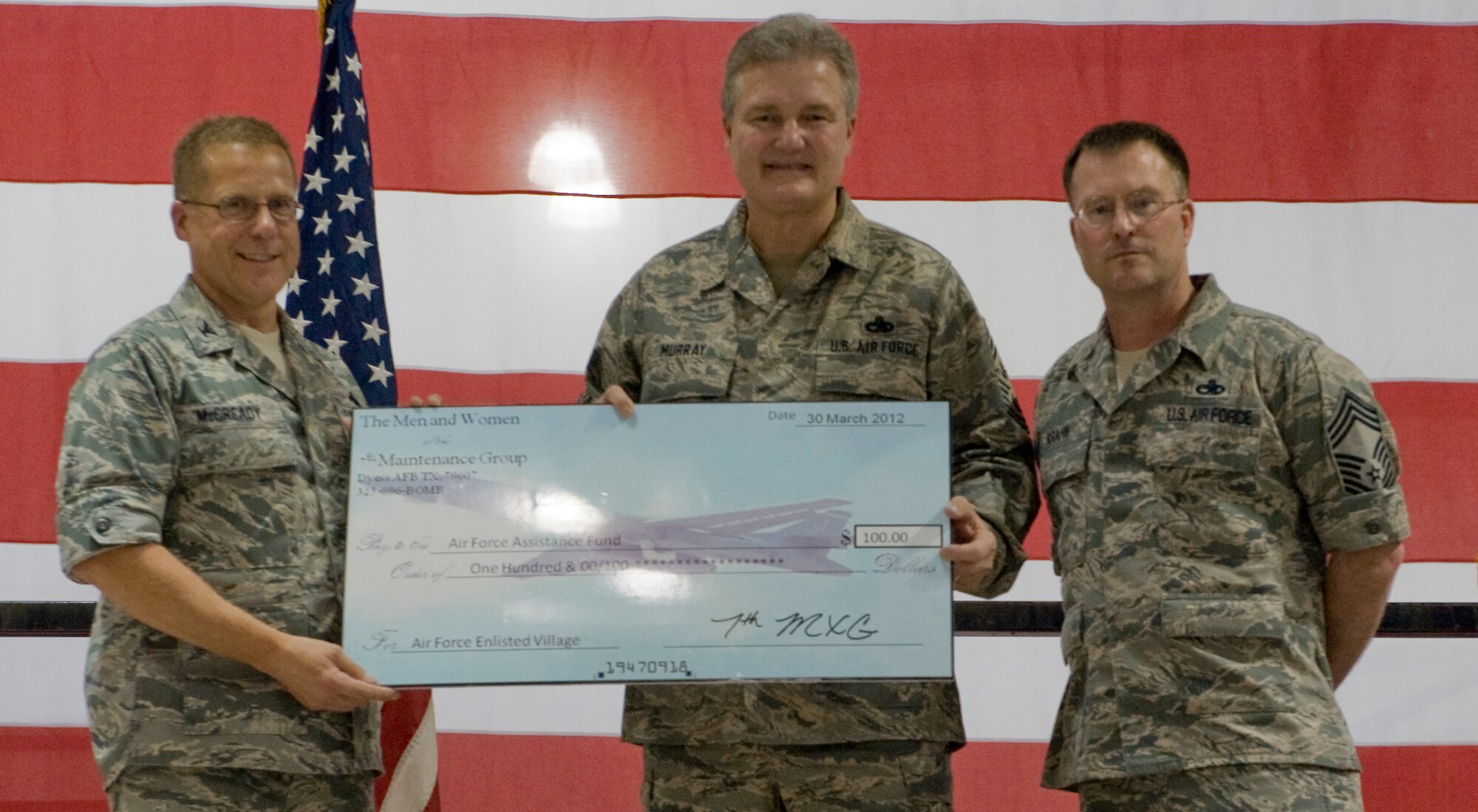 U.S. Air Force Col. Todd McCready, 7th Maintenance Group commander, left, presents a check to retired Chief Master Sgt. of the Air Force Gerald R. Murray, right, worth $100 dollorsfor the Air Force Assistance Fund March 30, 2012, at Dyess Air Force Base Texas. Murray was invited as a guest speaker for the 7th MXG Maintenance Professional of the Year Banquet, he also used his time at Dyess to visit various units on the base and meet Airmen. (U.S. Air Force photo by Airman 1st Class Jonathan Stefanko/ Released)