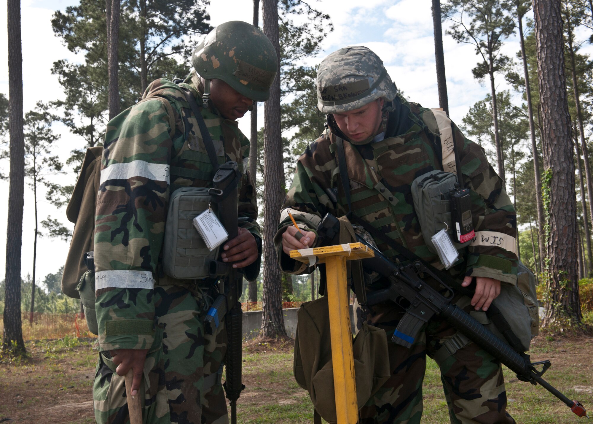 U.S. Air Force Airman 1st Class Christopher Banda and Senior Airman Mason Bennett, both from the 23d Civil Engineer Squadron, simulate the inspection of M-9 chemical agent detection paper during a phase II operational readiness inspection at the field training exercise site March 30, 2012, at Moody Air Force Base, Ga. For the past eight months, Team Moody has trained for the ORI with operational readiness exercises and has prepared to display their work to the Air Combat Command inspectors. (U.S. Air Force photo by Senior Airman Eileen Meier/Released)