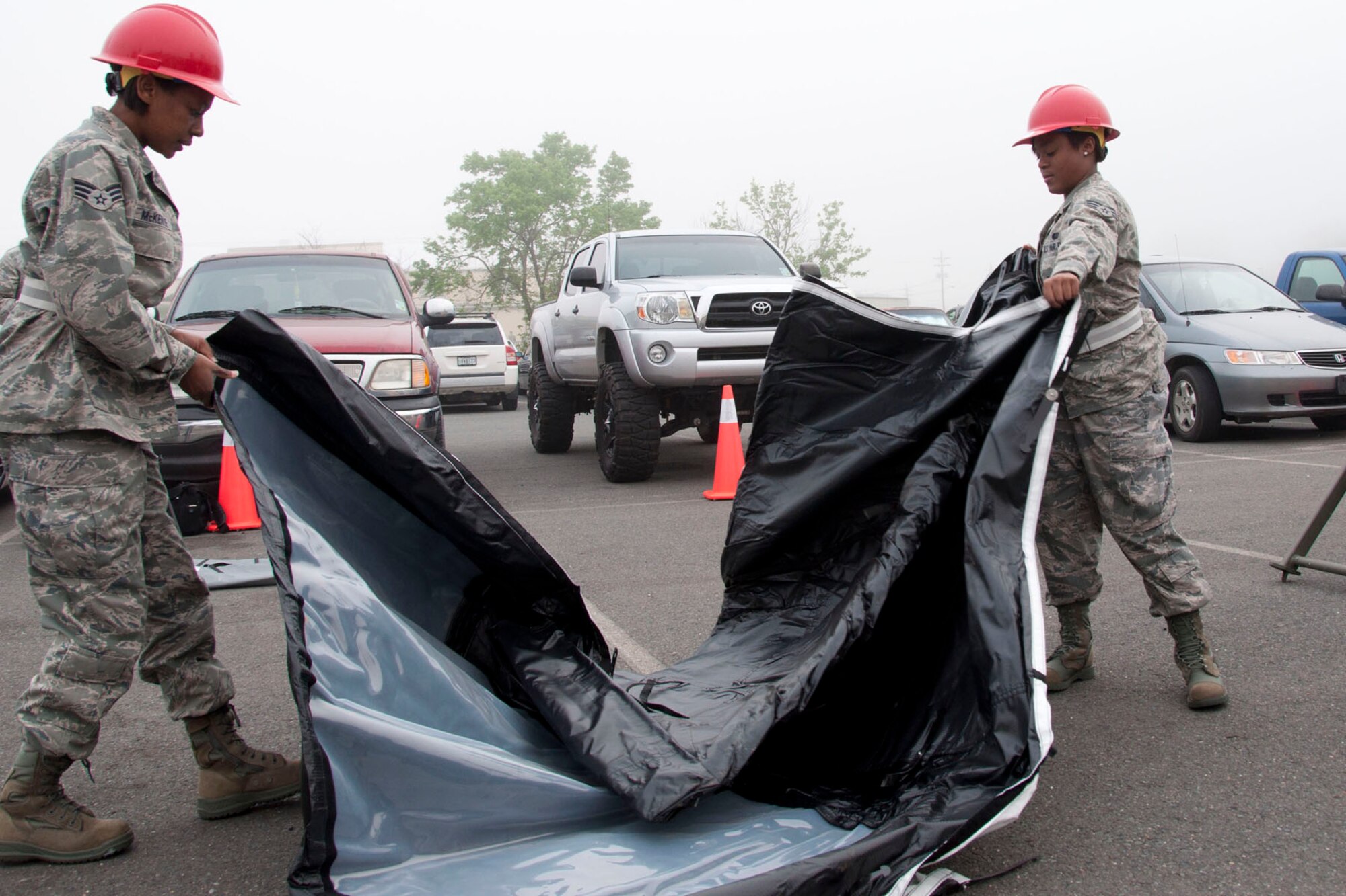 Senior Airman Angel McKenzie and Senior Airman Stephanie Hudson, 307th Services Squadron Morale, Welfare, Recreation and Service specialists, prepare a tent March 31, 2012, at Barksdale Air Force Base during practice for the John L. Hennessy Award competition.   Each year the Hennessy Award is bestowed upon best food service operation in the Air Force.  Units have to generate and serve meals in deployed conditions as part of the competition.  (U.S. Air Force photo by Staff Sgt. Ted Daigle/Released)