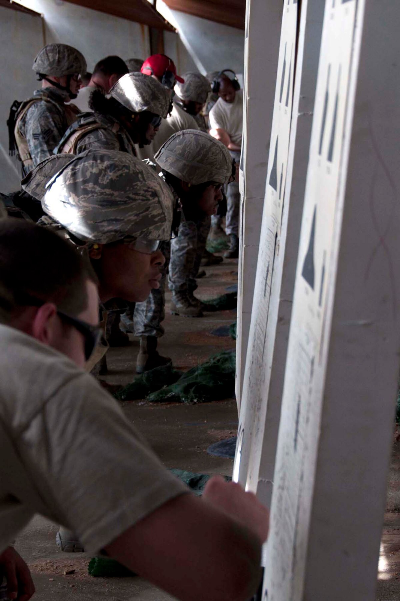 Members of the 307th Security Forces Squadron check their targets after a firing exercise March 31, 2012 at Barksdale Air Force Base, La.  A new course of fire enacted this year requires security forces members to qualify in a host of drills, including transitioning weapons during live fire and qualifying with a night vision scope.  The airmen spent nine hours on the range qualifying on the new standards. (U.S. Air Force photo by Staff Sgt. Ted Daigle/Released)