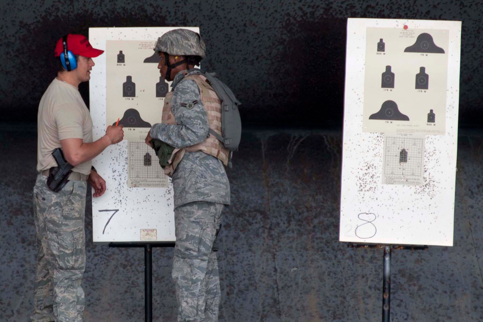 Staff Sgt. Joshua Feliciano and Airman 1st Class Stephen Boyd, 307th Security Forces Squadron combat arms journeymen, discuss the results of Boyd’s most recent effort during live fire exercises March 31, 2012 at Barksdale Air Force Base, La.  The exercise is part of the new course of fire required for all weapons-bearing Airmen.   Qualification under the new course of fire includes threat discrimination drills, shooting and moving drills and immediate action drills where Airman have to clear weapons while they fire.  (U.S. Air Force photo by Staff Sgt. Ted Daigle/Released)