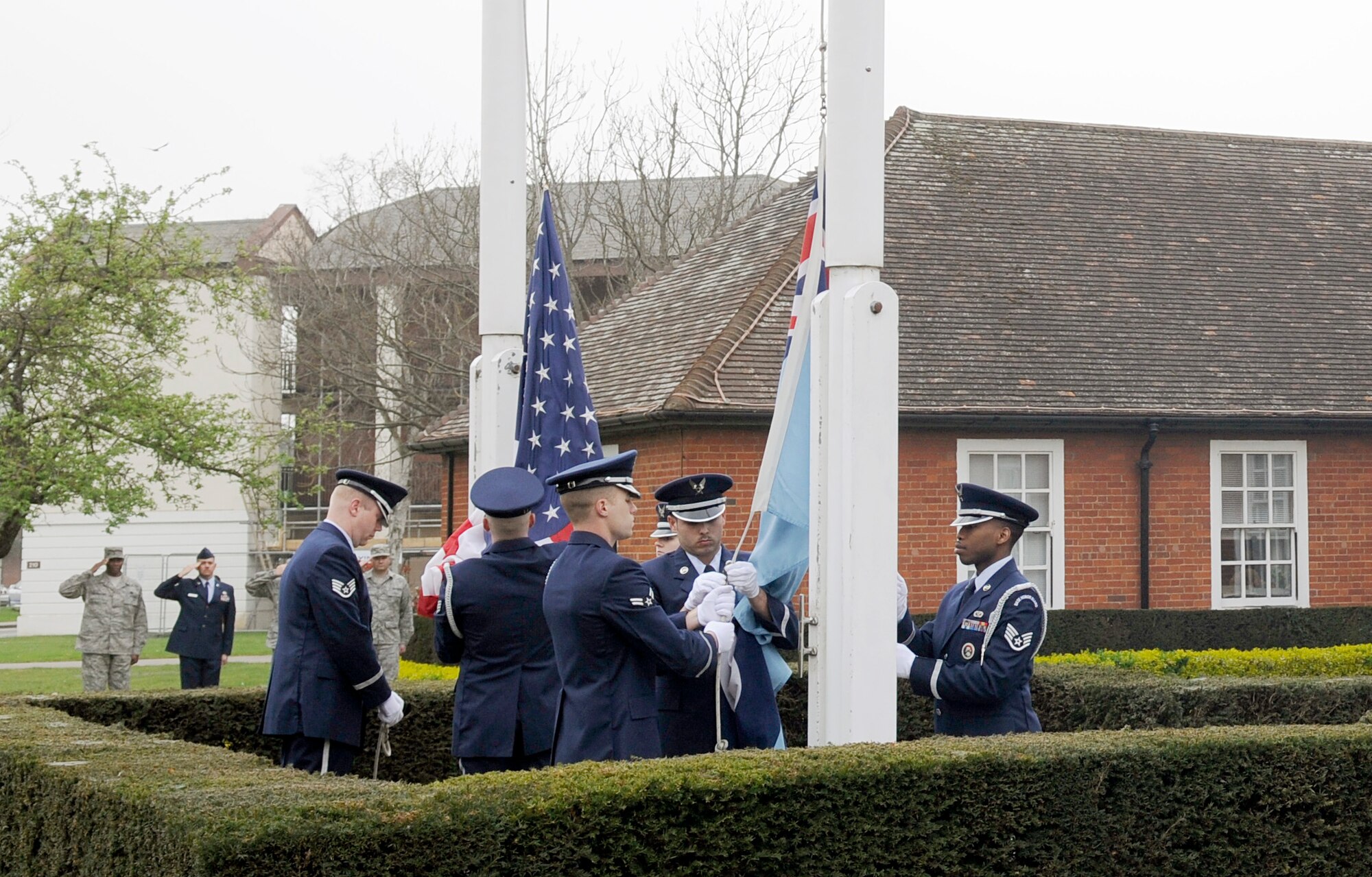 RAF MILDENHALL, England – Members of the RAF Mildenhall Honor Guard remove both the American and RAF insignia flags during a retreat ceremony here March 27, 2012.  Retreat signals the end of the duty day while also paying respect to the flag. (U.S. Air Force photo/Senior Airman Ethan Morgan)