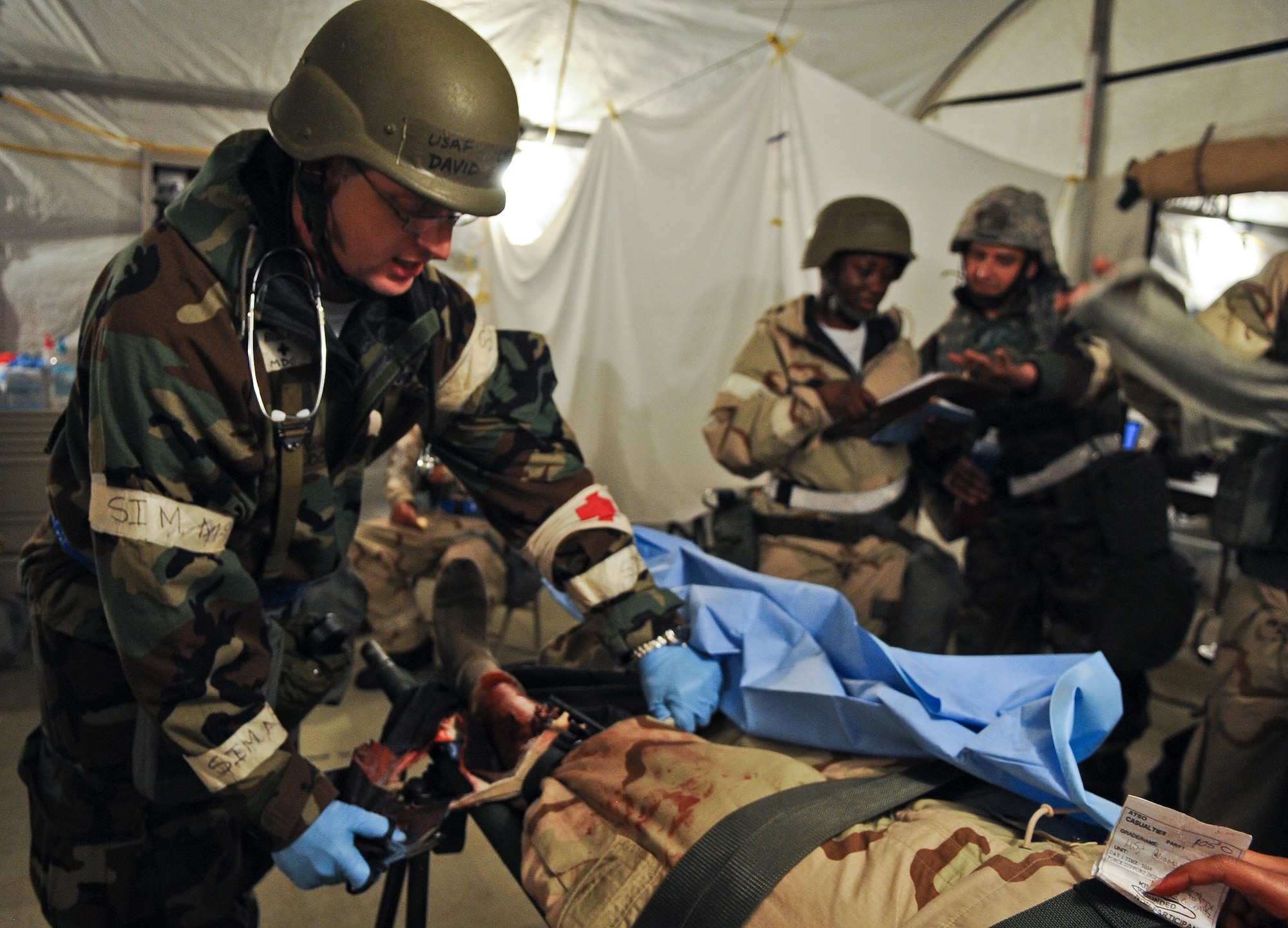 U.S. Air Force Lt. Col. (Dr.) David Blocker, 23d Aerospace Medicine Squadron flight surgeon, cuts gear off a simulated injured patient to treat a leg wound during a Phase II Operational Readiness Inspection at Moody Air Force Base, Ga., March 30, 2012. Throughout the inspection, Airmen were evaluated on their capability to perform the mission in a deployed setting. (U.S. Air Force photo by Airman 1st Class Olivia Dominique/Released) 