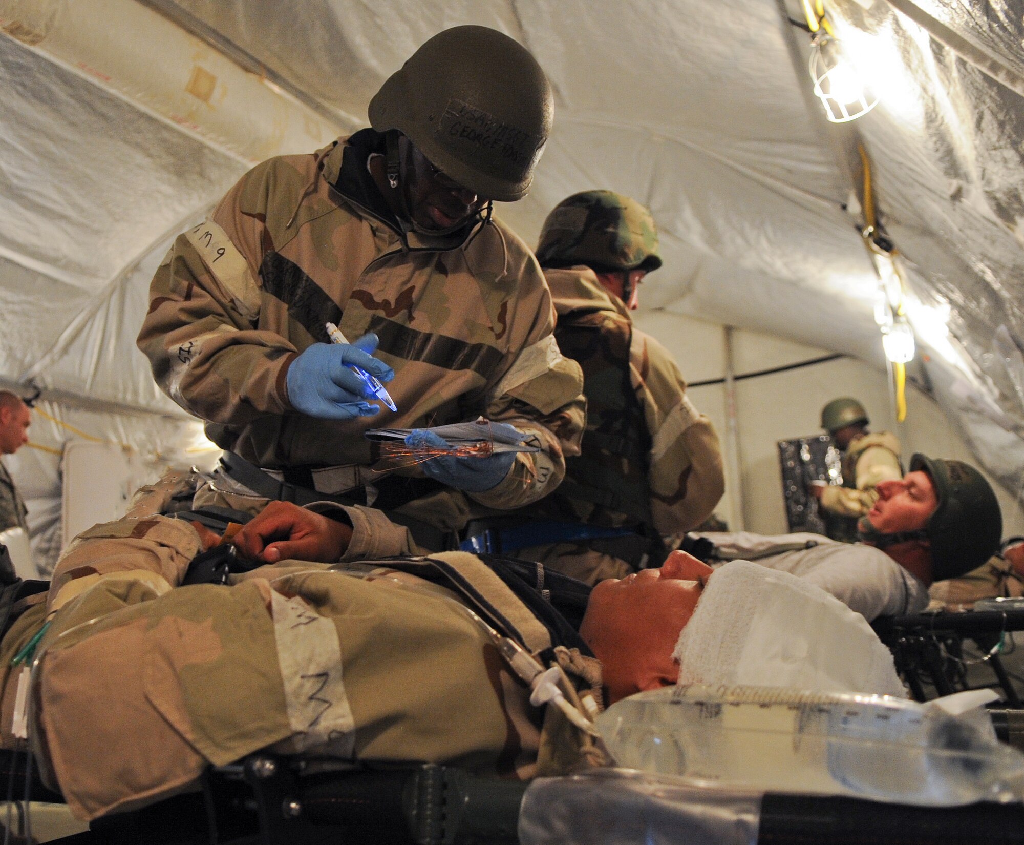 U.S. Air Force Master Sgt. George Foreman, 23d Aerospace Medicine Squadron flight chief, assesses injuries on a simulated patient during a Phase II Operational Readiness Inspection at Moody Air Force Base, Ga., March 30, 2012. During the inspection, members were evaluated on their knowledge and ability to function in a deployed environment. (U.S. Air Force photo by Airman 1st Class Olivia Dominique/Released)