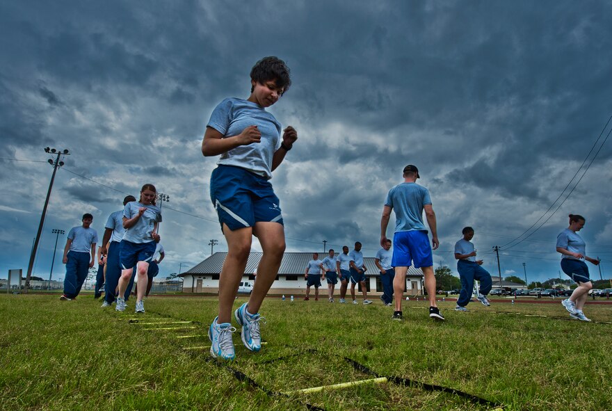 More than 20 Airmen perform linear drills during a physical training leader class March 30 at Eglin Air Force Base, Fla.  PTLs lead their flights and squadrons in group PT sessions during the week throughout the base.  (U.S. Air Force photo/Samuel King Jr.)
