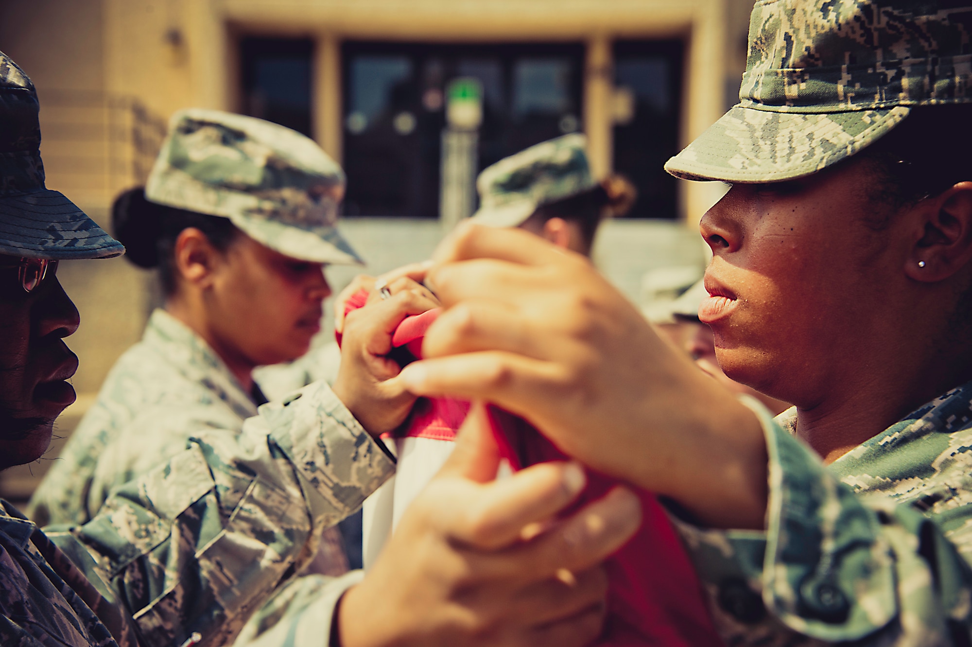 Members of the flag detail bring the flag together at the retreat ceremony March 29.  The flag detail and flight positions were filled by women in honor of Women’s History Month.  More than 30 women participated in the ceremony.  To see more photos of the all-women flag detail go to facebook.com/teameglin.  (U.S. Air Force photo/Samuel King Jr.)