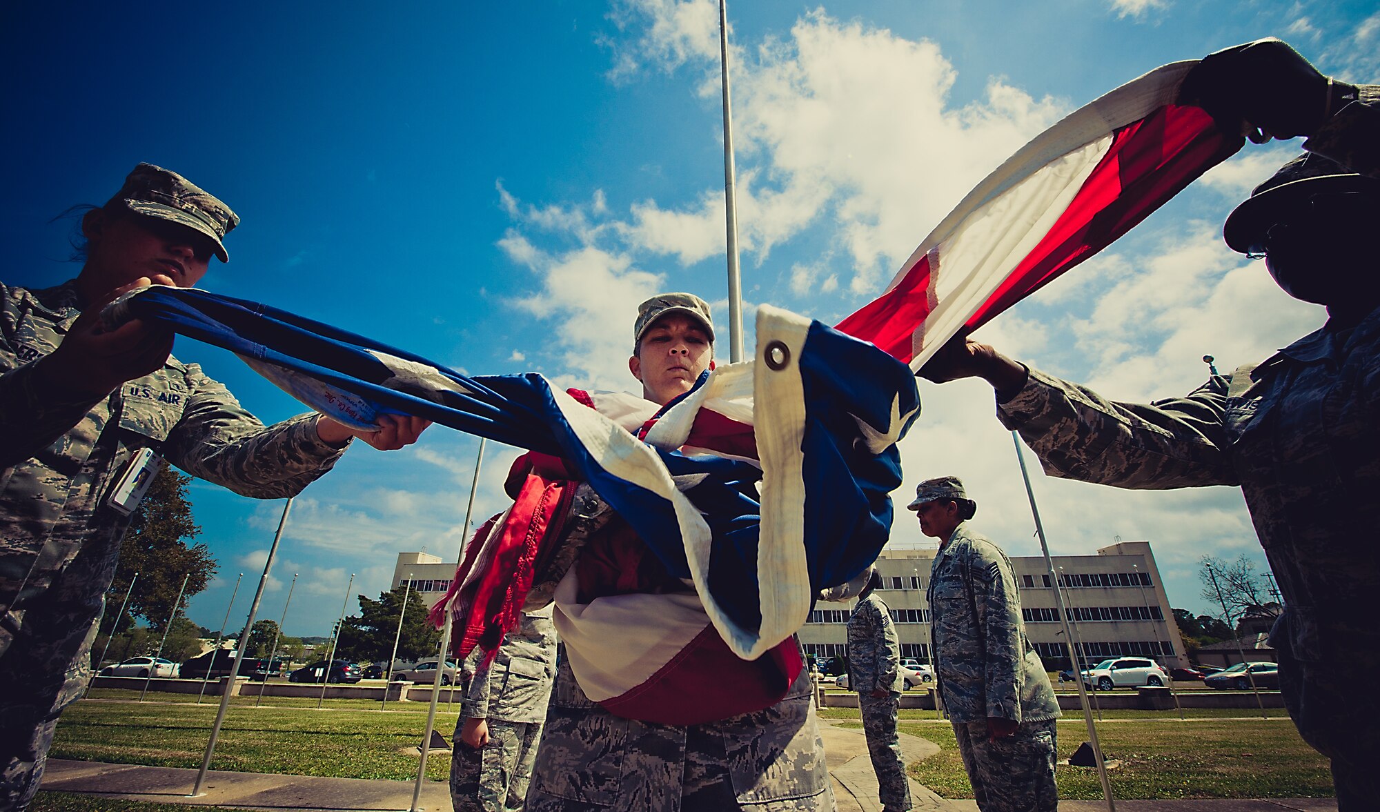 Master Sgt. Deaira Smith, Air Force Operational Test and Evaluation Center, Detachment 2, holds the flag as members of the flag detail grab the corners during the practice prior to the retreat ceremony March 29.  The flag detail and flight positions were filled by women in honor of Women’s History Month.  More than 30 women participated in the ceremony.  To see more photos of the all-women flag detail go to facebook.com/teameglin.  (U.S. Air Force photo/Samuel King Jr.)