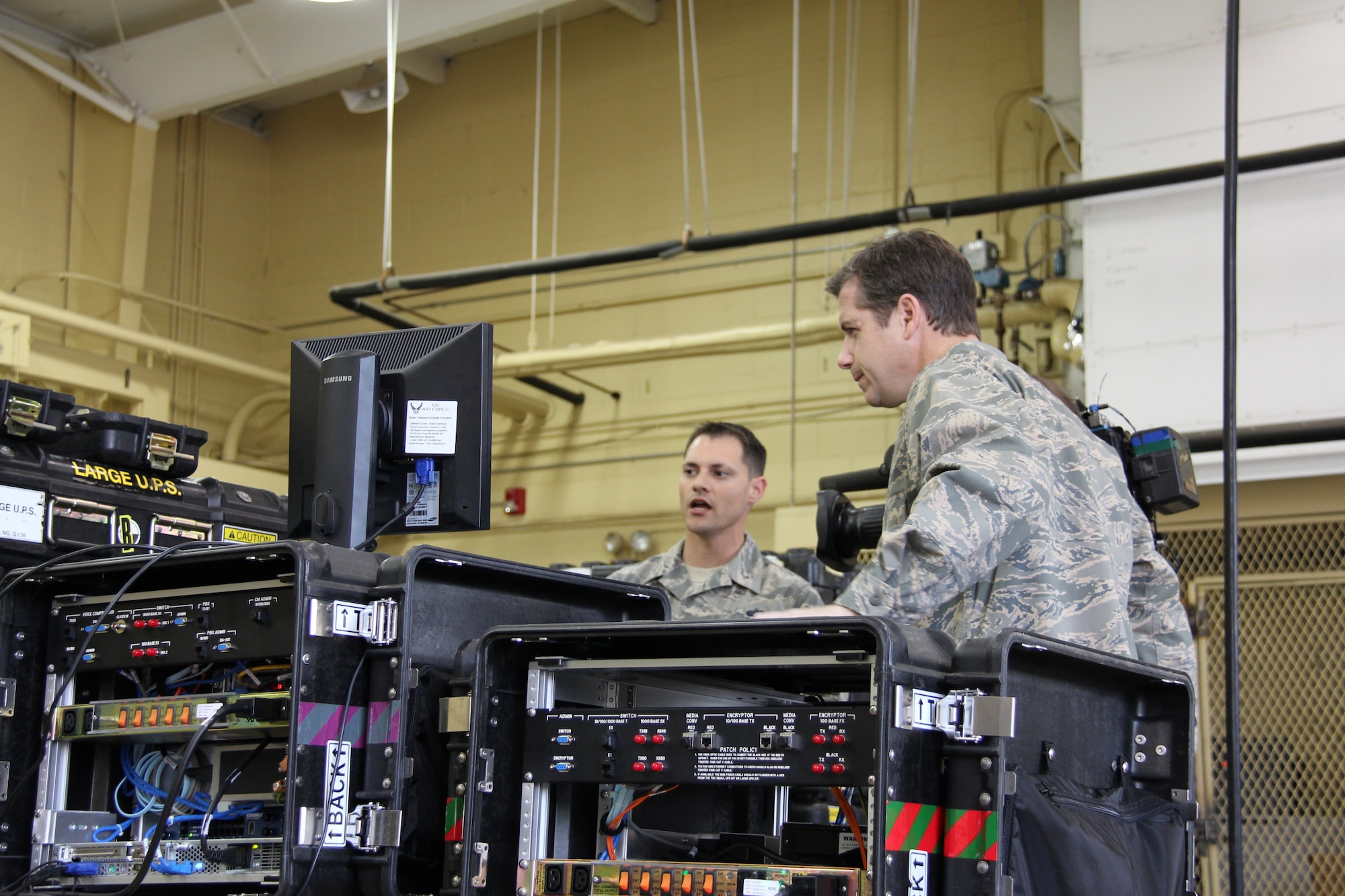 Tech. Sgt. Aaron Arcega, 52nd Combat Communications Squadron cyber transport operator, briefs Reynolds Wolf, CNN meteorologist and correspondent, on the portable voice and data communications equipment, a key component to extend and defend the network here March 28. A three-person CNN team visited the 689th Combat Communications Wing to experience what it is like to be a combat communications Airman for the day. Combat Comm provided hands-on experiences that showcased the physical, technical, and mental readiness of Combat Communicators.  (U.S. Air Force photo by Robert Talenti)