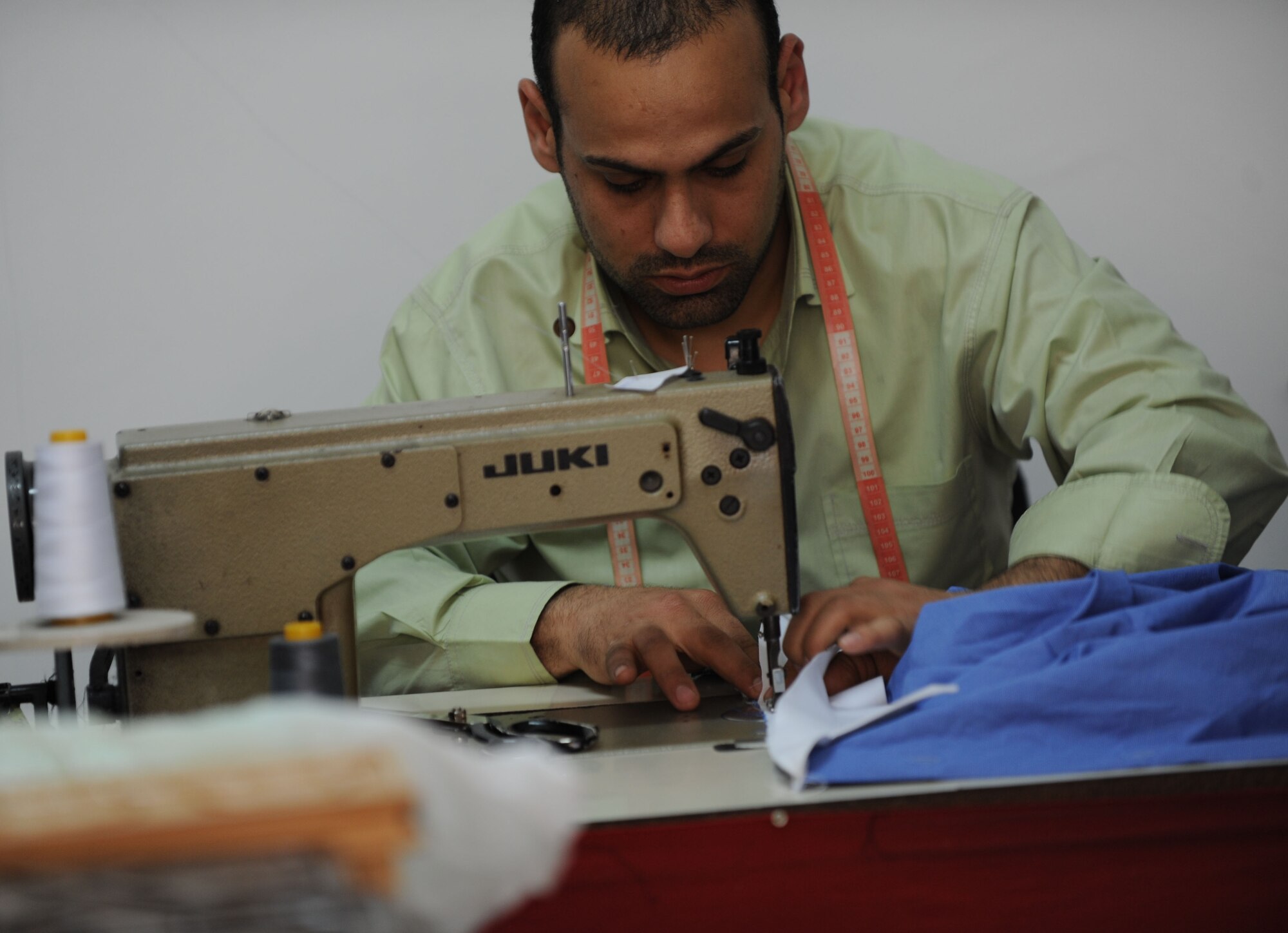 Veysel Arsay, Couzin's Tailor Shop tailor,  stitches a shirt collar March 29, 2012, in Incirlik Village, Turkey. The shop is registered with the Incirlik Village Merchants Association, which was founded approximately 20 years ago with the objective to improve relationships with American customers. (U.S. Air Force photo by Senior Airman Jarvie Z. Wallace/Released)