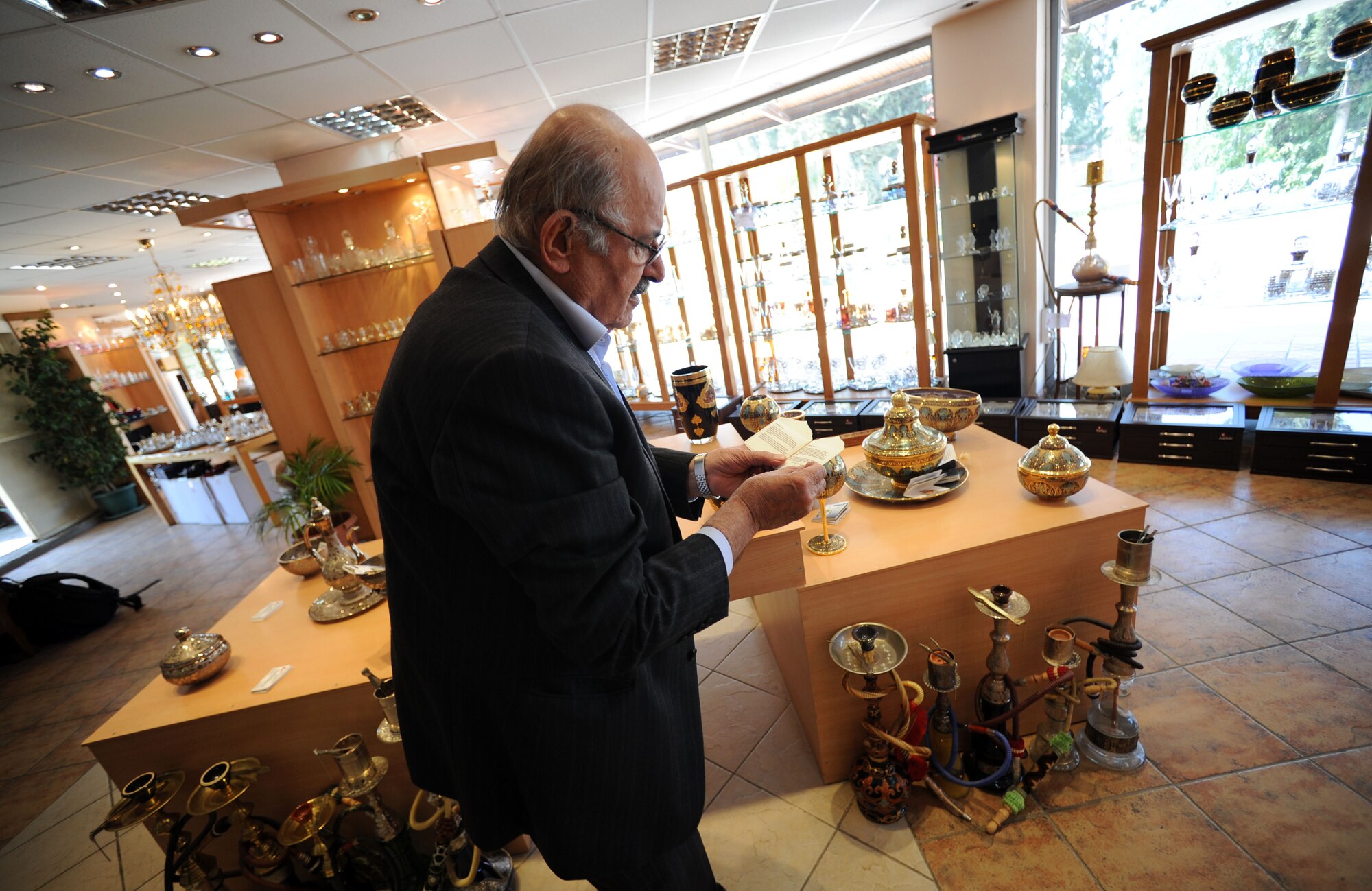 Abdulkerim Estetik, Incirlik Village Merchants Association president, reads a certificate of a prized candleholder March 29, 2012, in Incirlik Village, Turkey. The IVMA was founded approximately 20 years ago with the objective to improve relationships with American customers. (U.S. Air Force photo by Senior Airman Jarvie Z. Wallace/Released)
