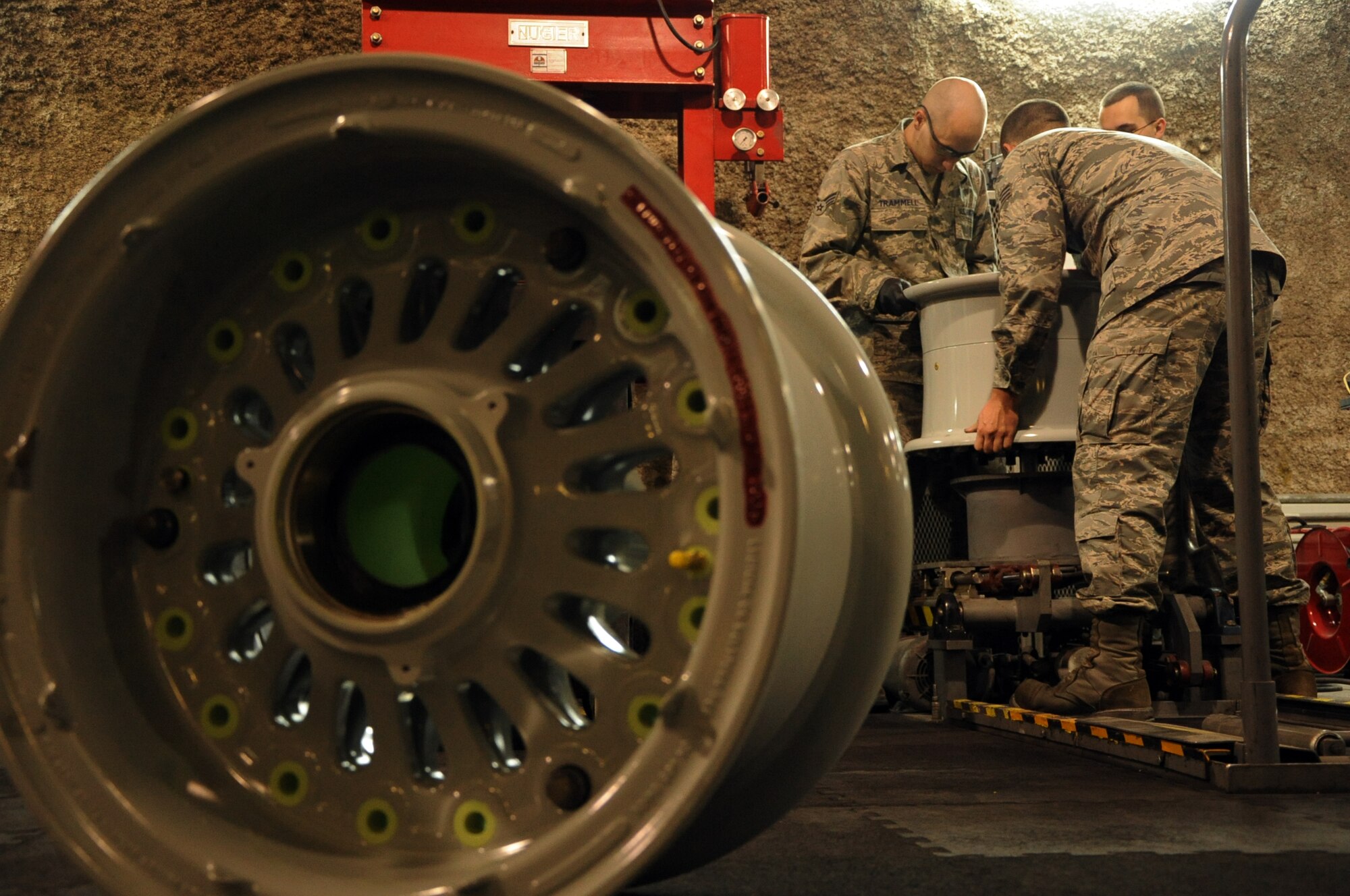 SOUTHWEST ASIA – Airmen from the 379th Expeditionary Maintenance Squadron Wheel and Tire Shop lift an aircraft rim during a routine inspection March 29. The wheel and tire shop conducts wheel and tire maintenance services and inspections for seven different airframes including the F-16, C-130, KC-135, and B-1. It also supports wheel and tire services from bases throughout Southwest Asia.