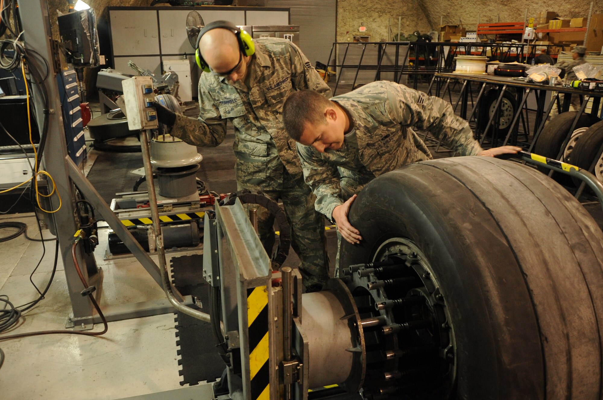 SOUTHWEST ASIA – Senior Airmen Blake Trammell and Tyler Blevins, 379th Expeditionary Maintenance Squadron Wheel and Tire Shop technicians, break the “bead” of an aircraft wheel during a routine inspection March 29. The “bead” is the portion of the tire that connects the tire and the rim of the wheel causing an airtight seal.  The wheel and tire shop conducts wheel and tire maintenance services and inspections for seven different airframes including the F-16, C-130, KC-135, and B-1. It also supports wheel and tire services from bases throughout Southwest Asia.