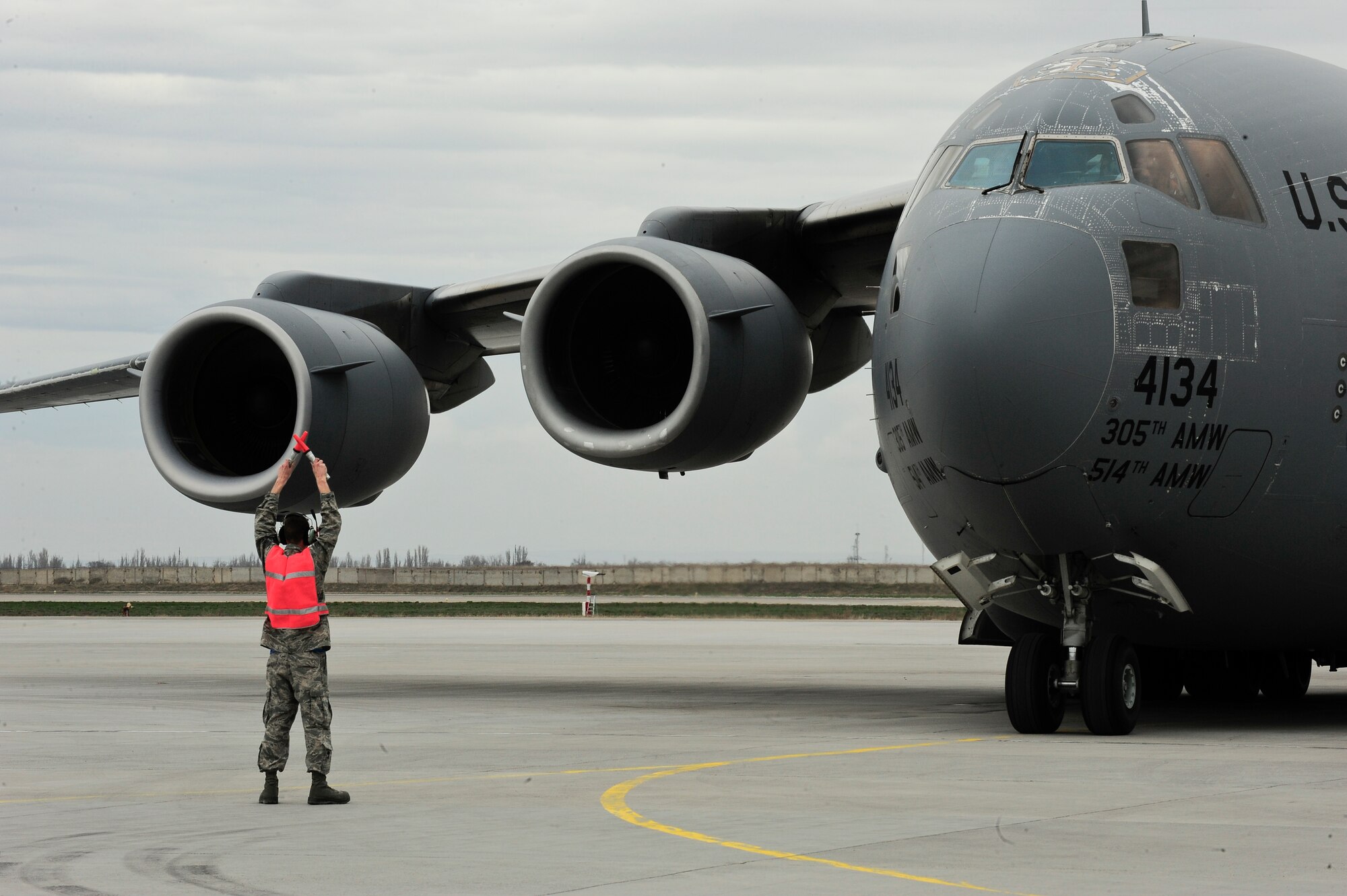 An Airman marshalls a C-17 Globemaster III into a parking spot on the flight line April 1, 2012, at the Transit Center at Manas, Kyrgyzstan. The C-17 Globemaster III's maximum payload capacity is 170,900 lbs. The aircraft carried the U.S. Marine Corps Gen. James Mattis, commander of U.S. Central Command, for a visit to the Transit Center. (U.S. Air Force photo/Staff Sgt. Angela Ruiz)
