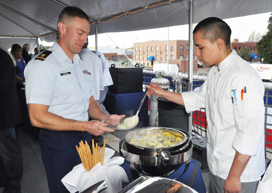 U.S. Coast Guard Seaman Apprentice Christopher Lopez, a food service specialist "A" school student from Training Center Petaluma, Calif., serves food to Ensign Charles Wilson, a crew member aboard the U.S. Coast Guard Cutter Stratton, during a reception held aboard the ship in Alameda, Calif., March 28, 2012. The 418-foot Stratton will be the third national security cutter in service with the Coast Guard. 
