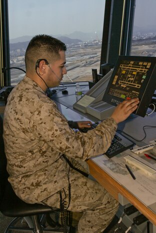 Lance Cpl. Jose A. Martinez, Headquarters and Headquarters Squadron air traffic controller, records and helps to plan aircrafts’ ability to use the runways from the air traffic control tower here April 2. Schedules are constantly changing on the runways and air traffic controllers balance in coming, out bound and touch-and-go aircrafts’ use of the runways in order to prevent problems and keep the station running smoothly.